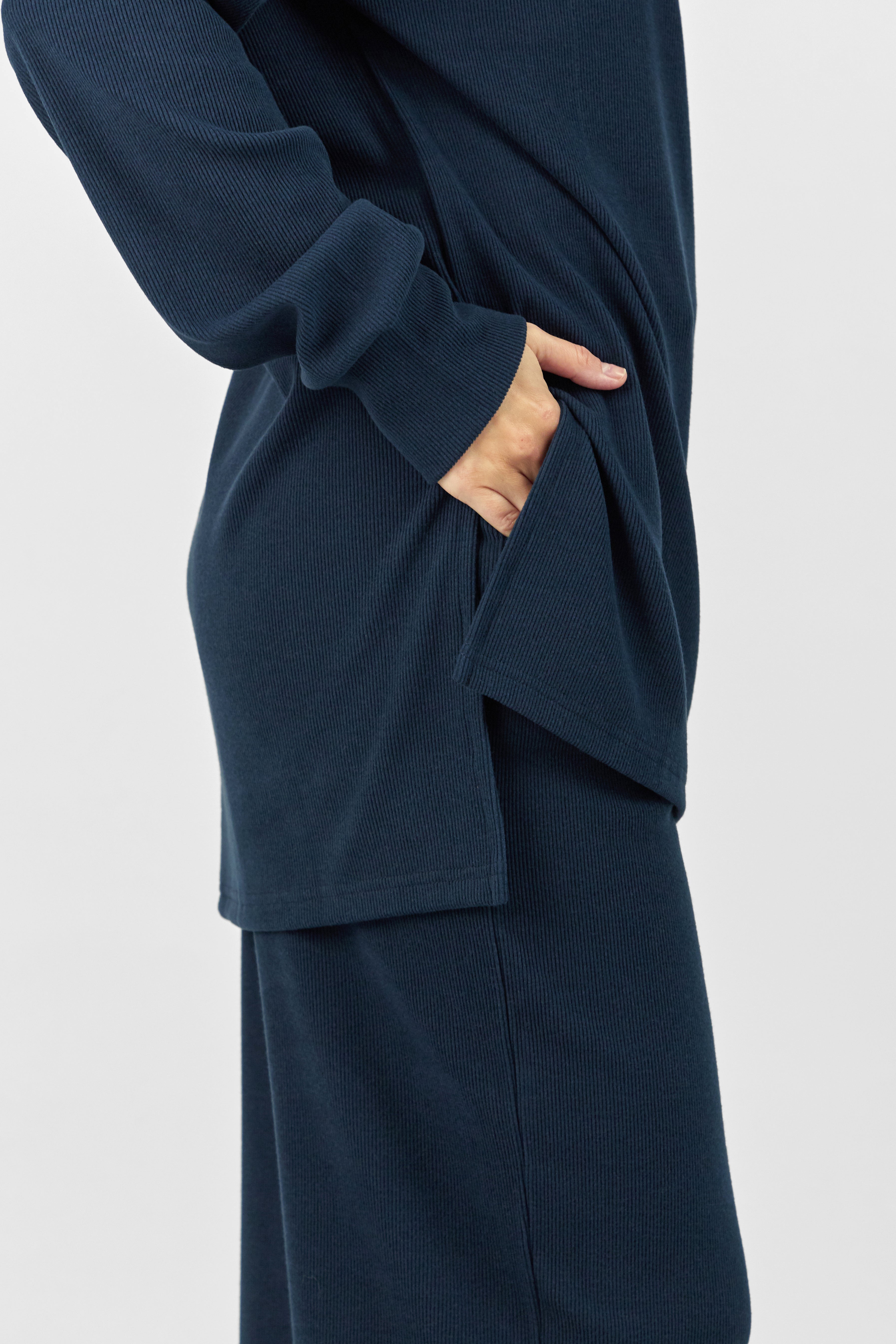 A girl turned to the right wearing FARES' velour knit half zip sweater. Colour description: Navy Blue.