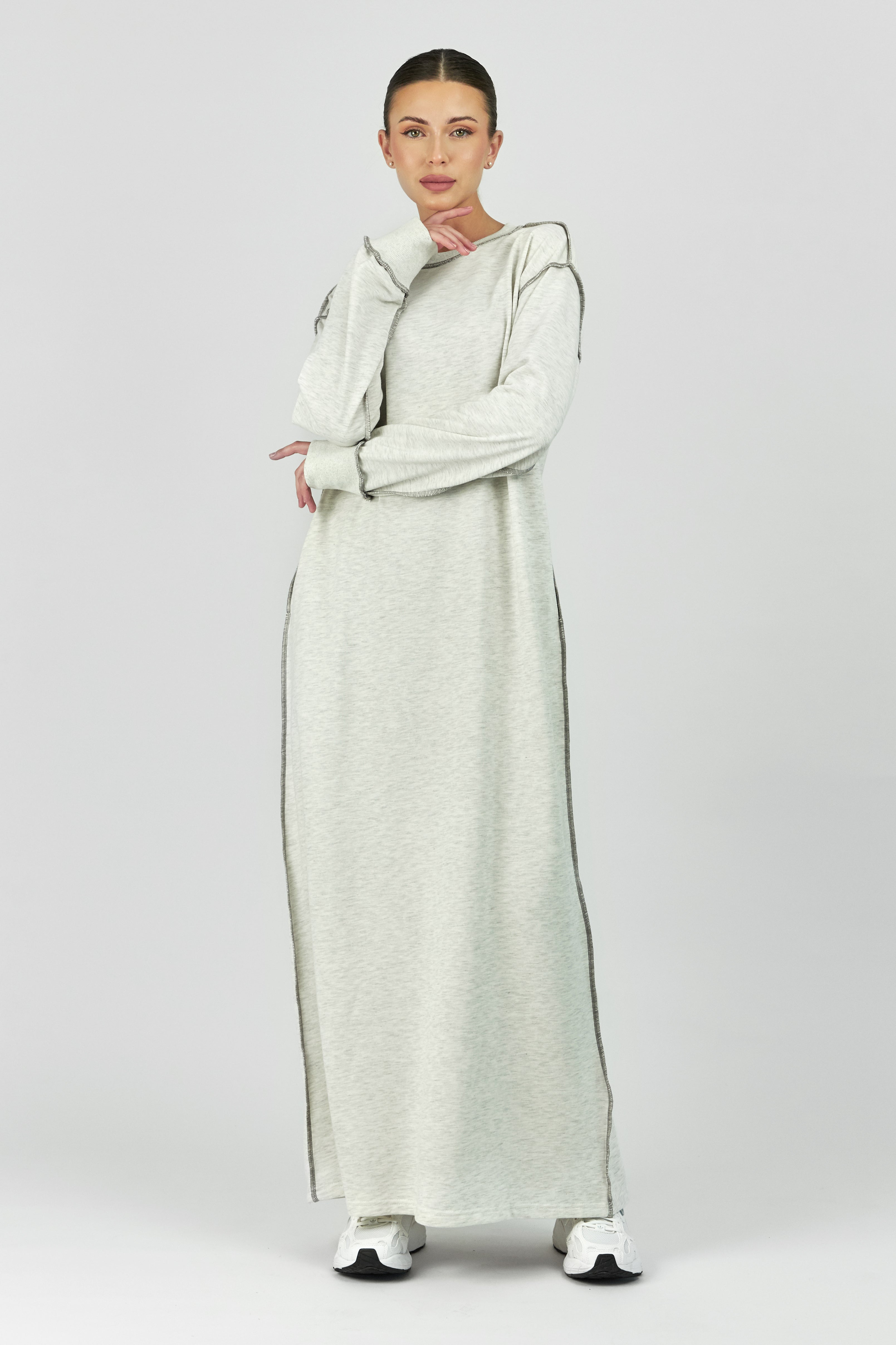 Colour: Warm Grey. A girl in a front pose in a contrast stich dress.