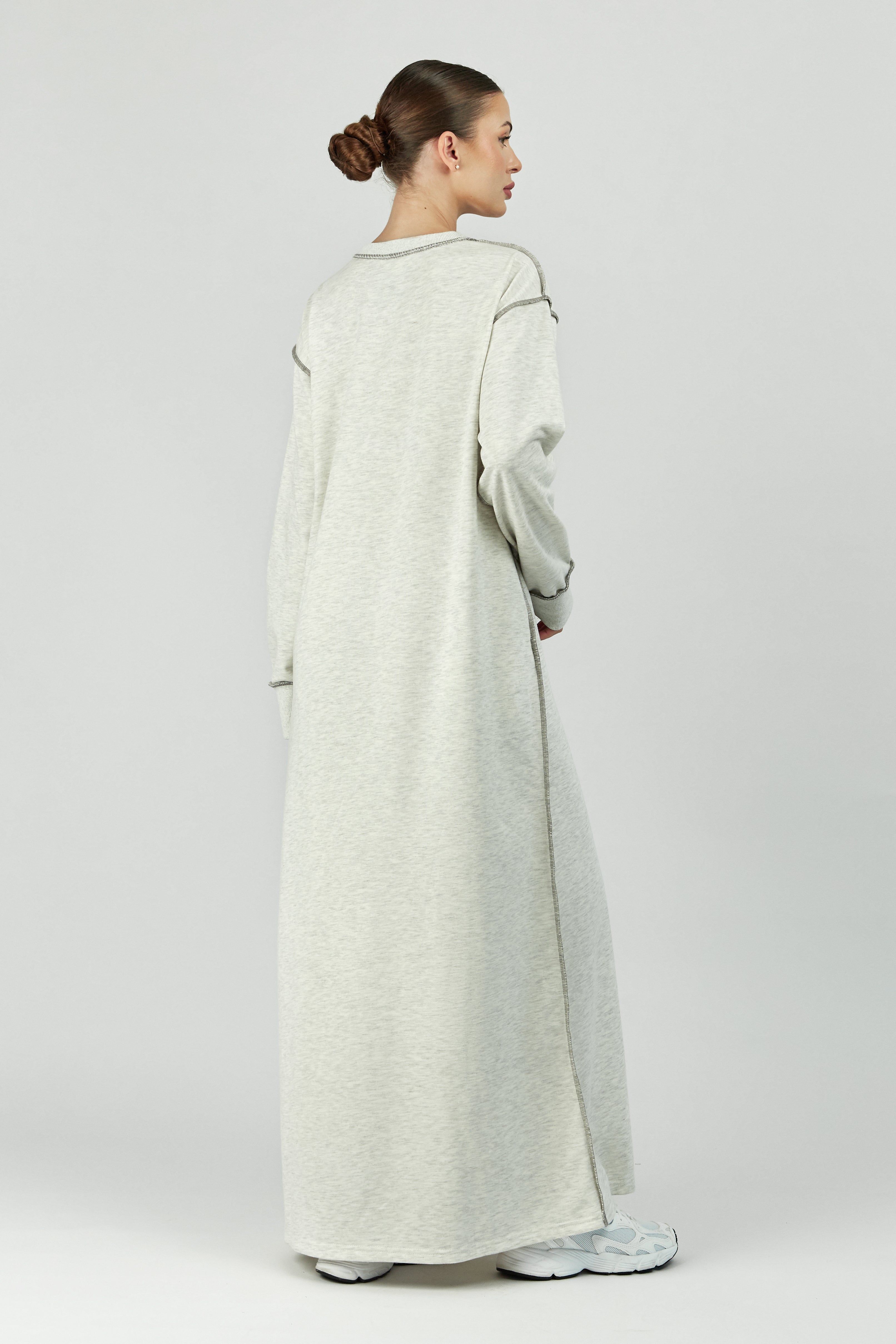 Colour: Warm Grey. A back pose of a model in a contrast stich dress.