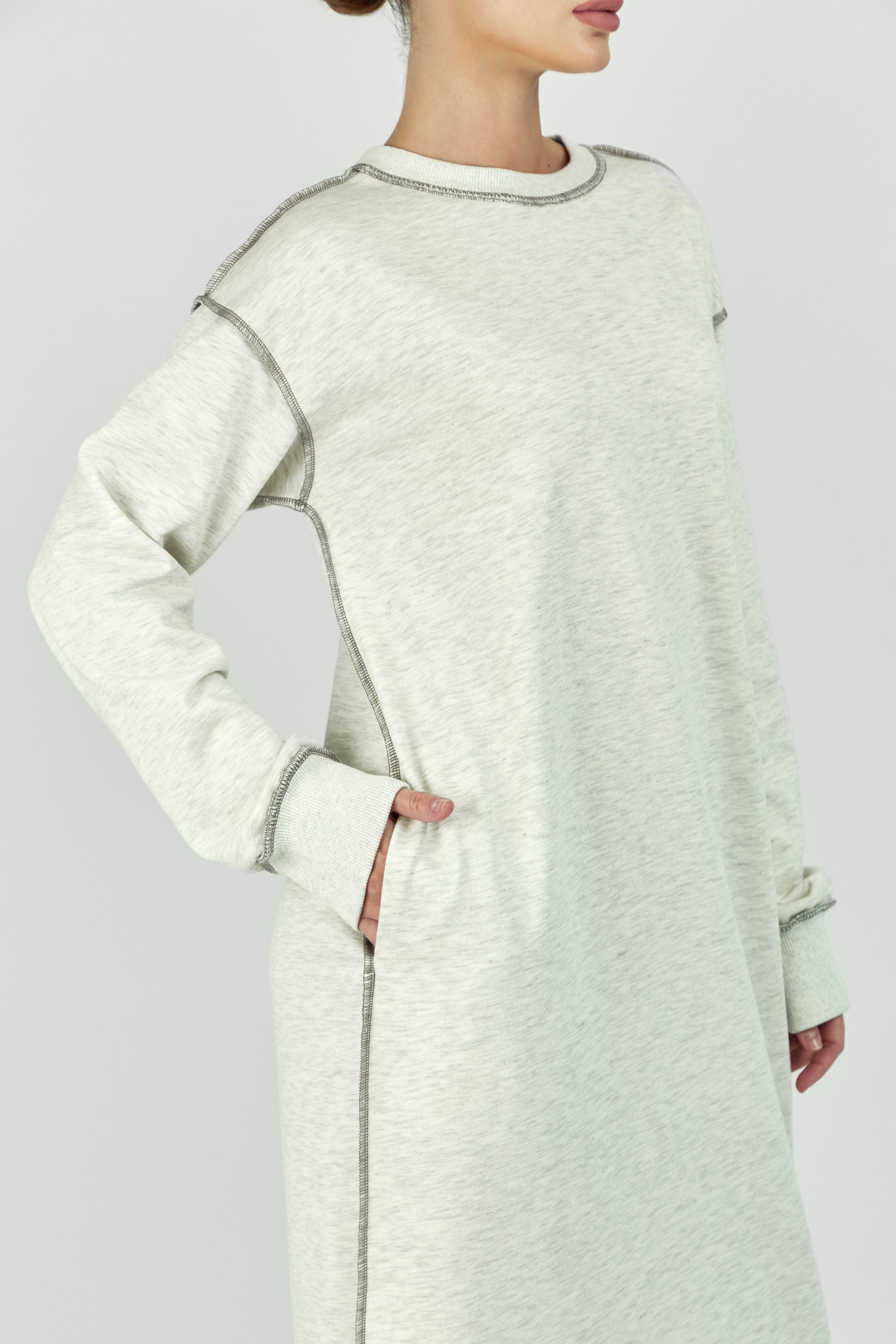 Colour: Warm Grey. A model with her hand in her pocket in a contrast stich dress.