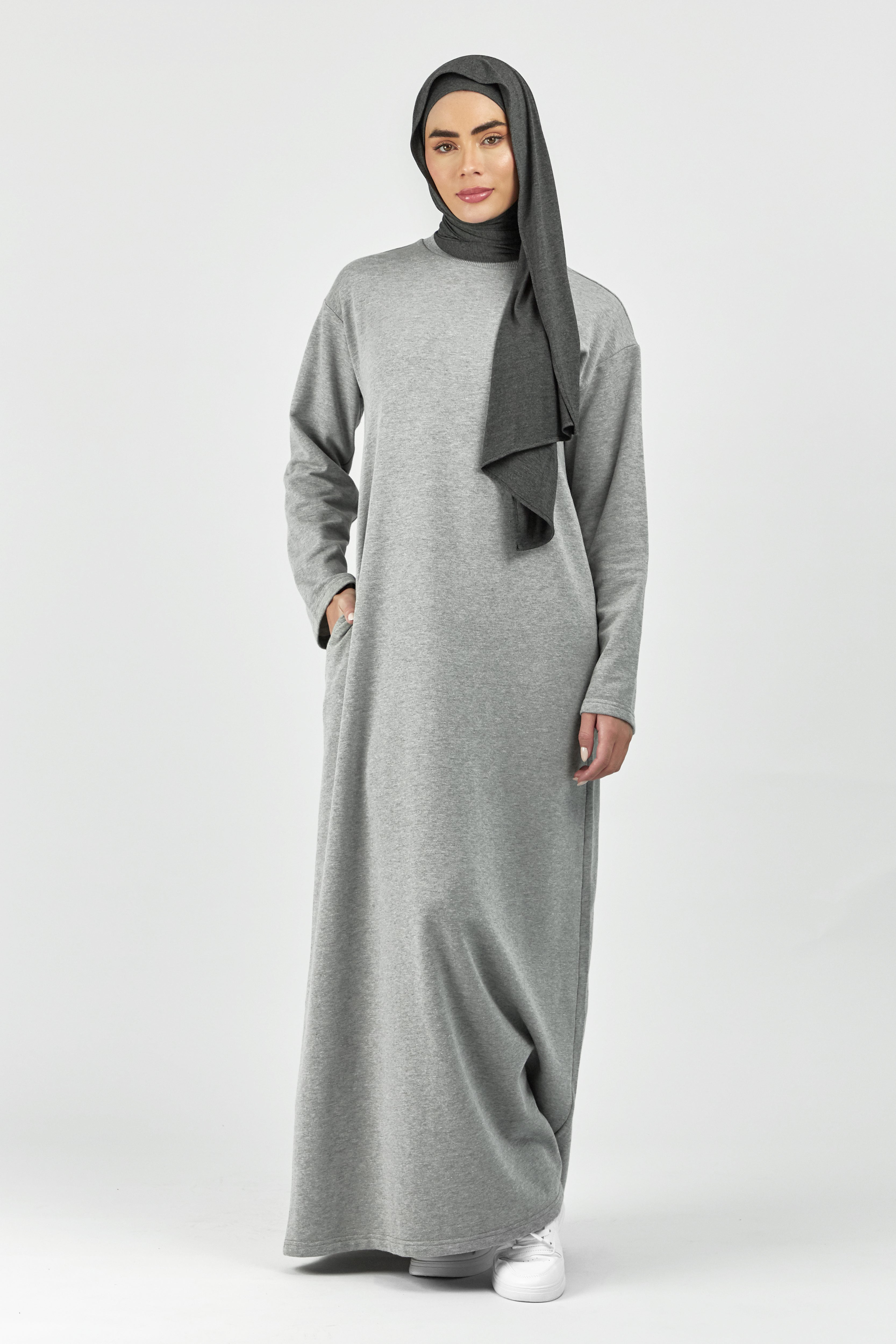Colour: Grey. A model in a front pose with her hand in her pocket wearing a wide sleeve sweatshirt dress.