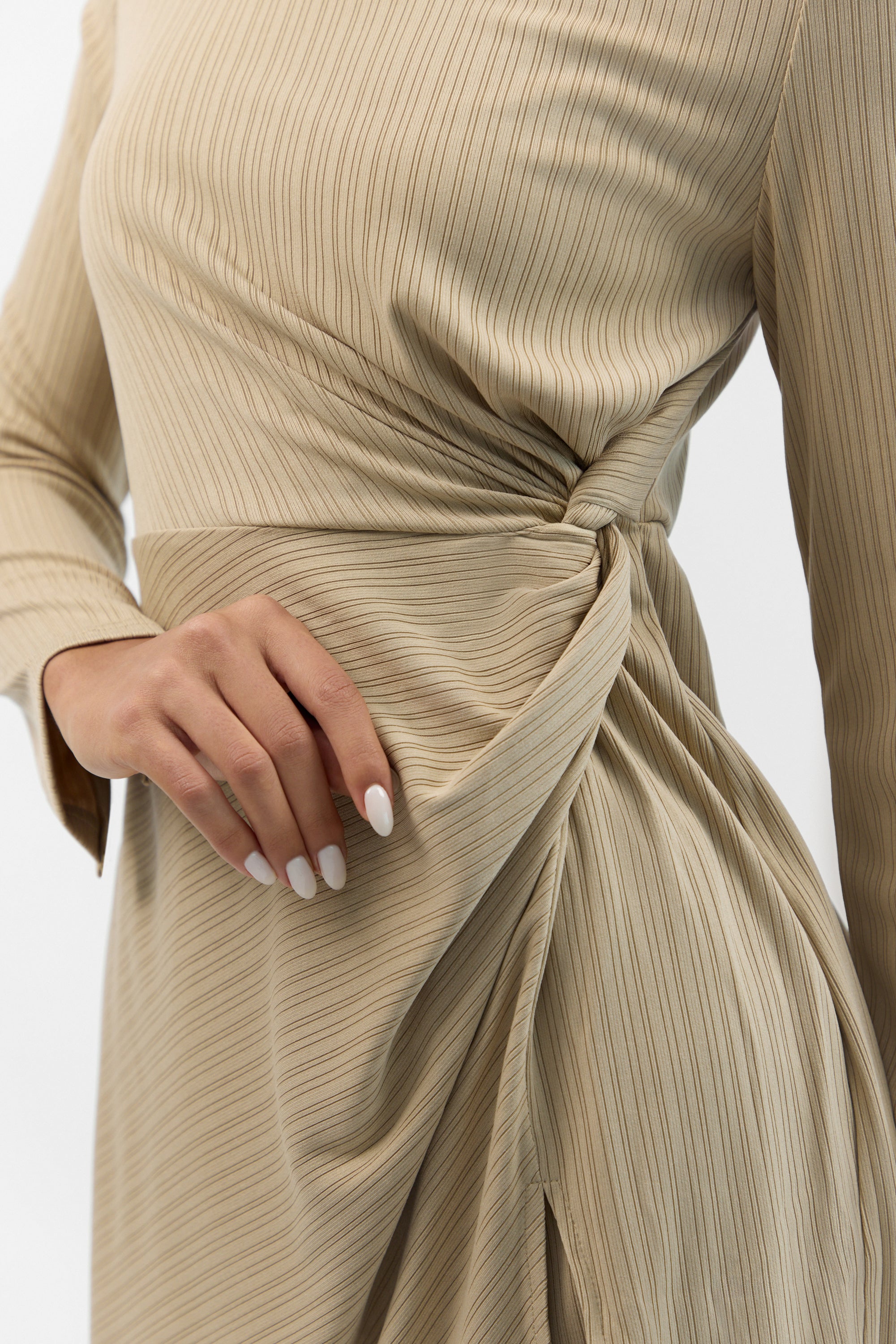 Detail of the ribbed texture and side twist accent on the FARES Ribbed Side Twist Top in Beige.