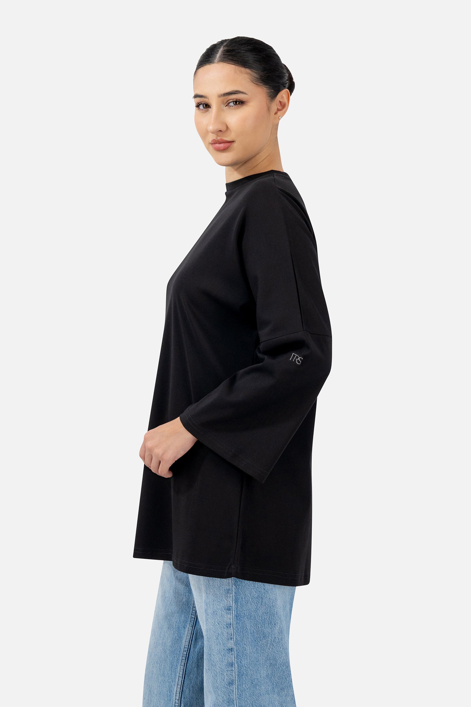 Side profile of the Black Cotton Long-Sleeve Tee highlighting the oversized silhouette.