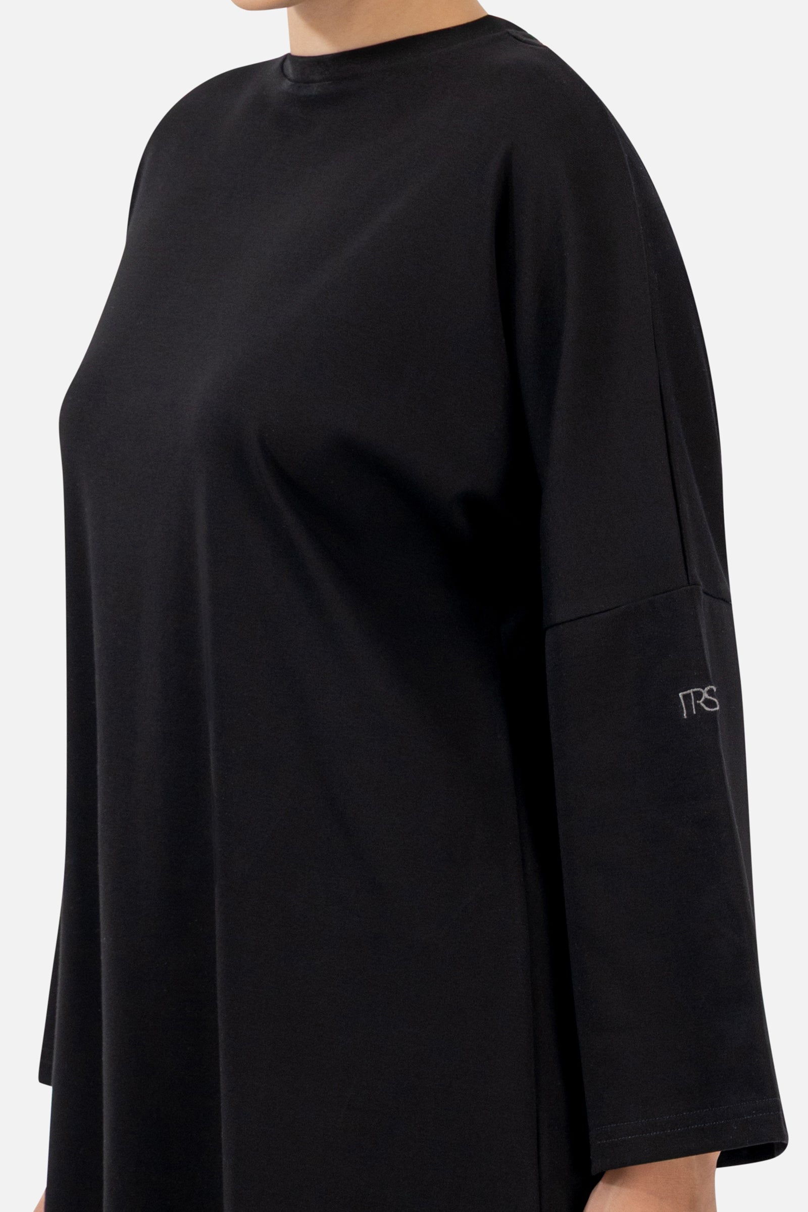 Close-up of the soft cotton fabric and wide sleeve detail on the Black long-sleeve T-shirt.
