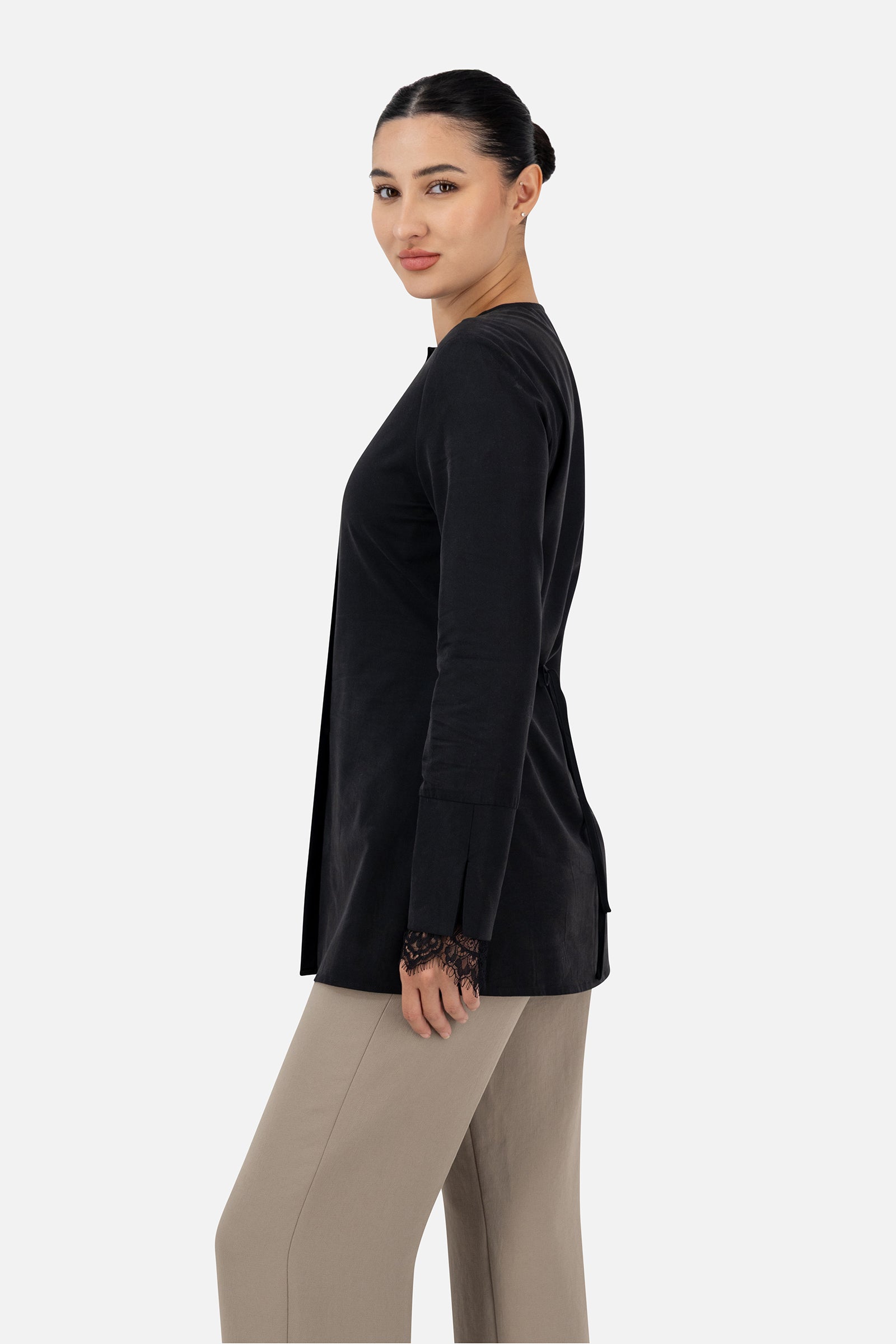 Side profile of the Black button-up long-sleeve top on the model.