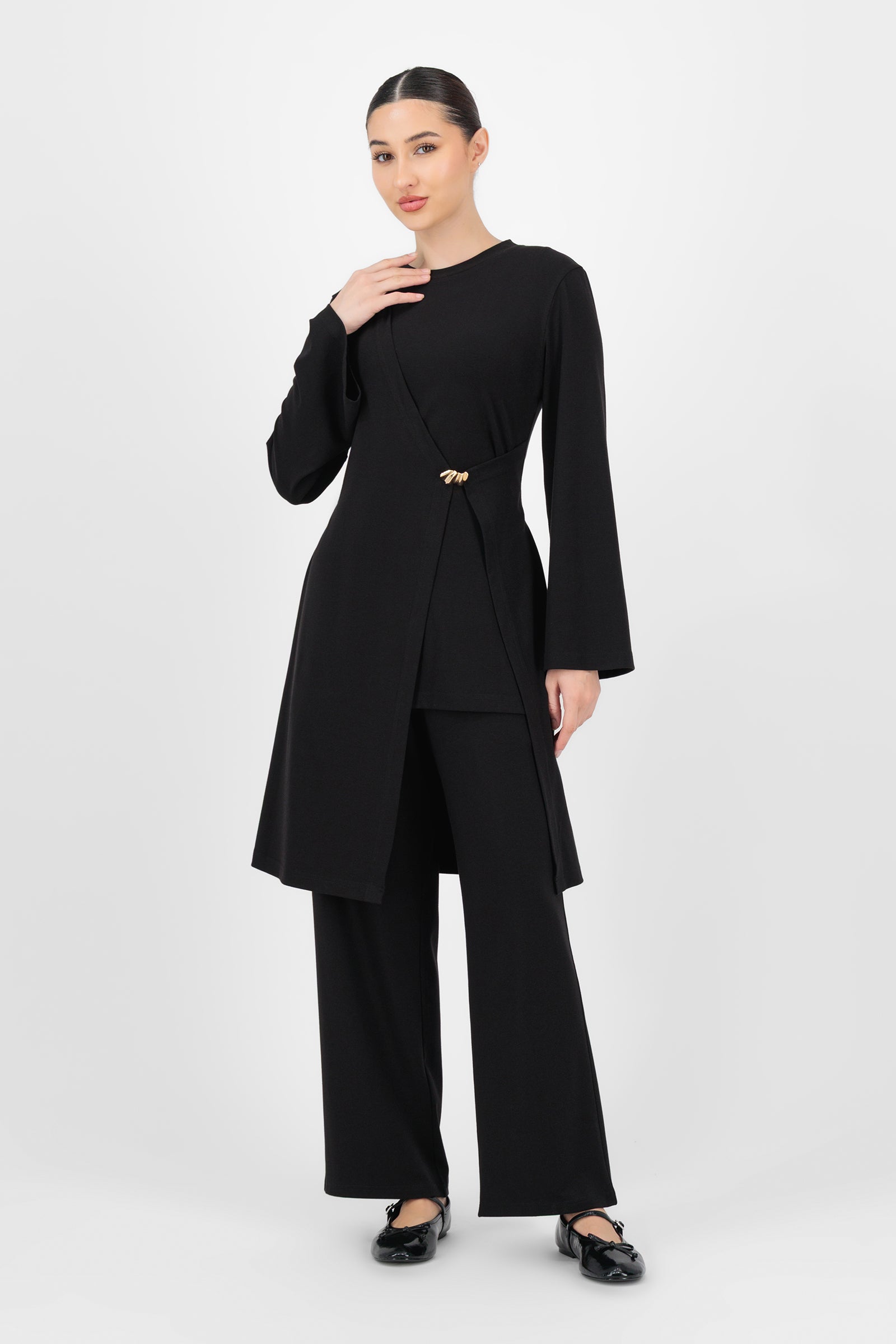 Full-body shot of the model wearing the Black Elastic Waist Straight Leg Trouser styled simply to highlight the timeless, flattering shape of these trouser pants for women.