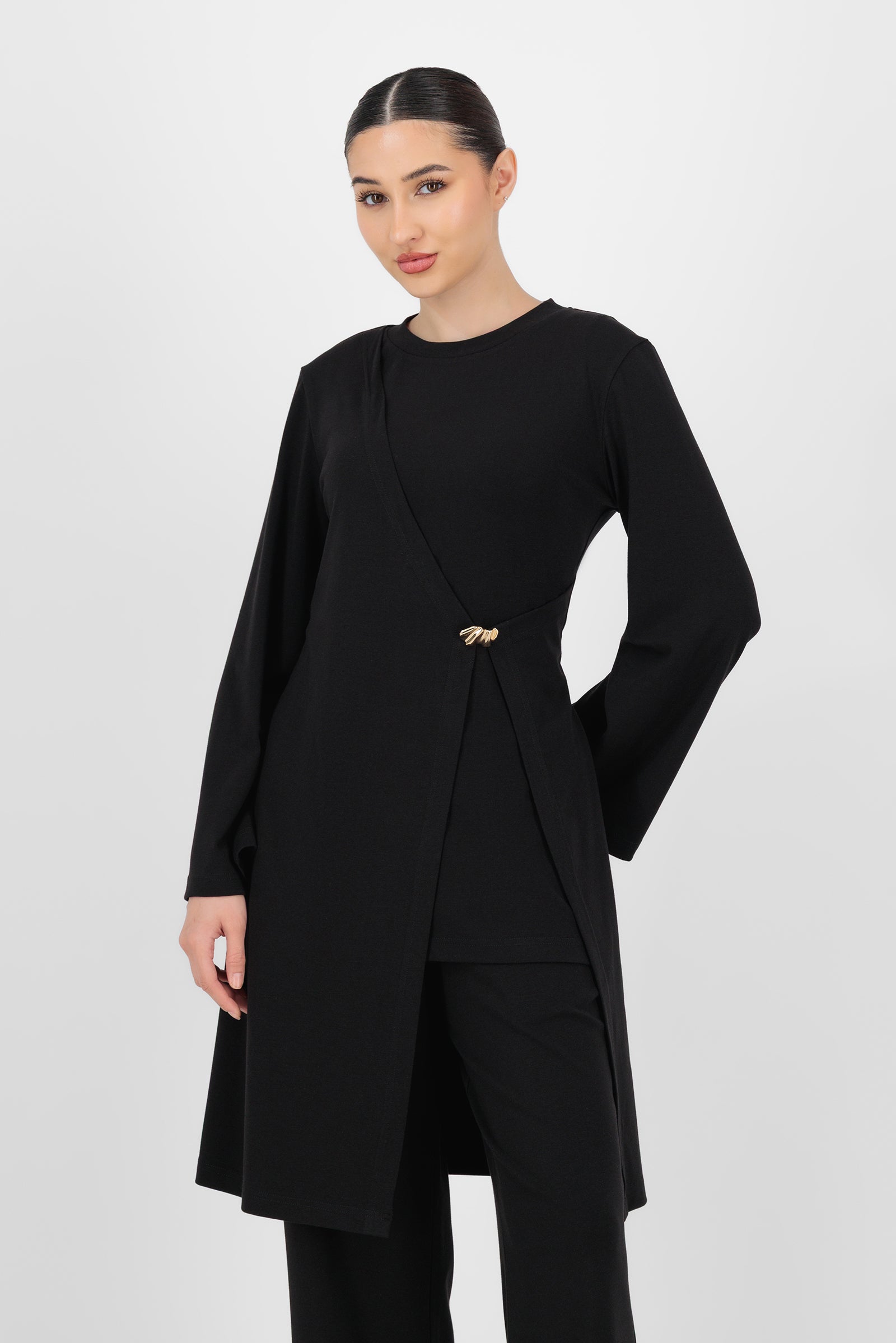 Model wearing the Gold Accent Wrap Top in Black front view, showing the flattering crossover fit and subtle gold detail that elevate this long sleeve wrap top.