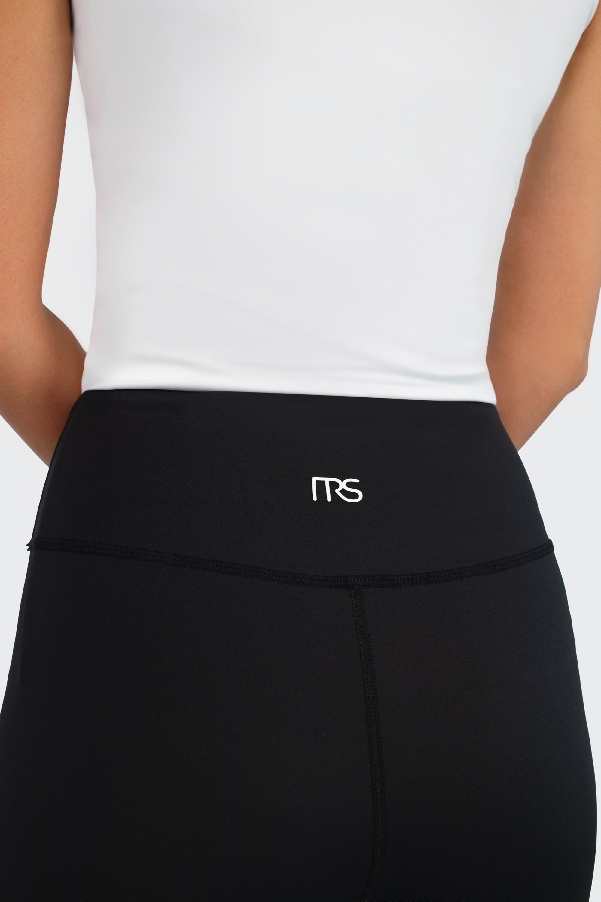 Model adjusting the zipper of the FARES Zip-Up Quick-Dry Modest Swim Set in Black Polka, showcasing the comfortable and functional design of this swim suit.