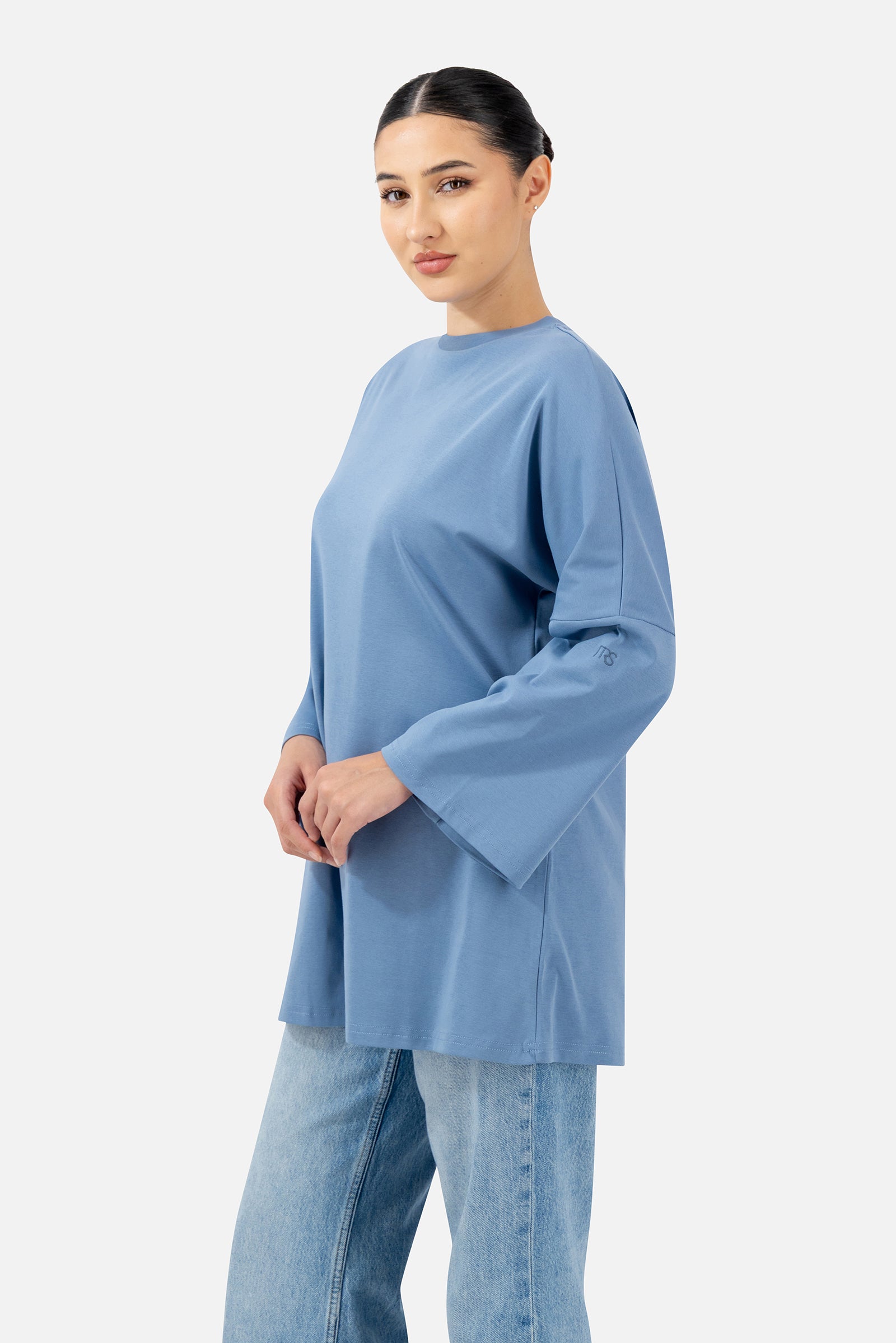 Side profile of the Denim Blue Cotton Long-Sleeve Tee highlighting the oversized silhouette.