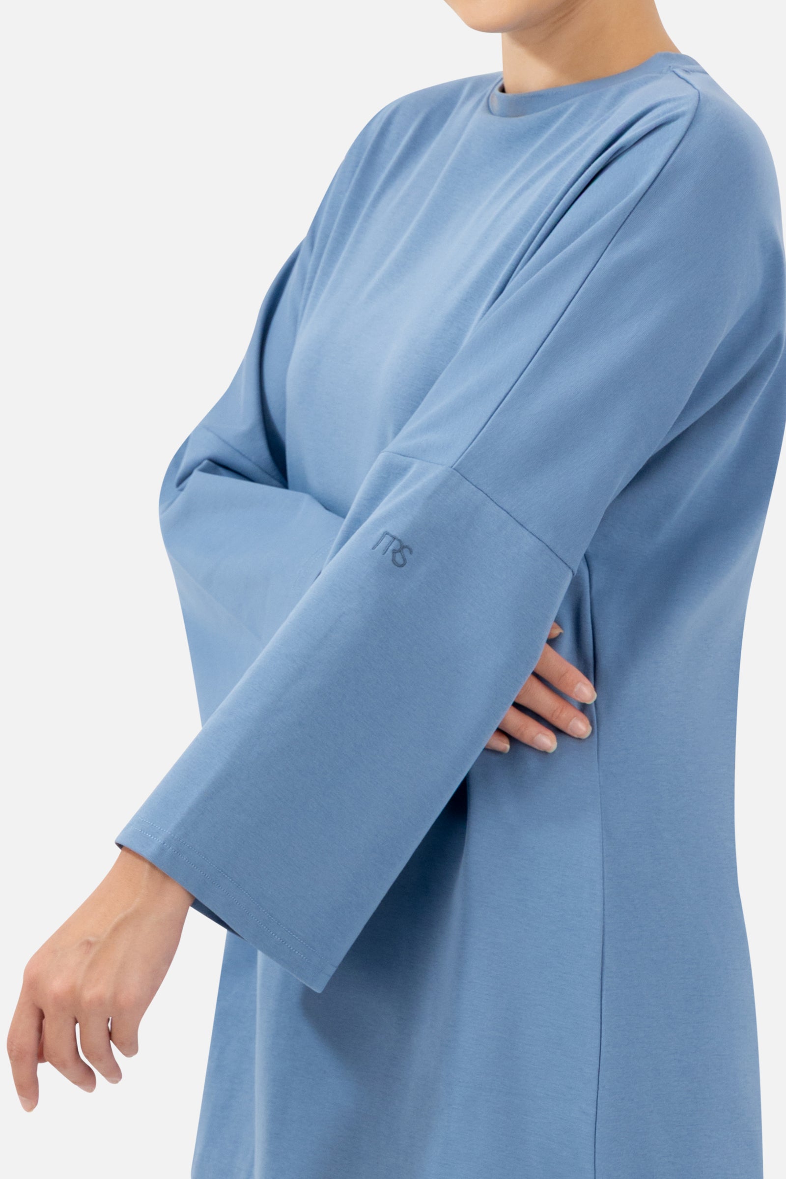 Close-up of the soft cotton fabric and wide sleeve detail on the Denim Blue long-sleeve T-shirt.