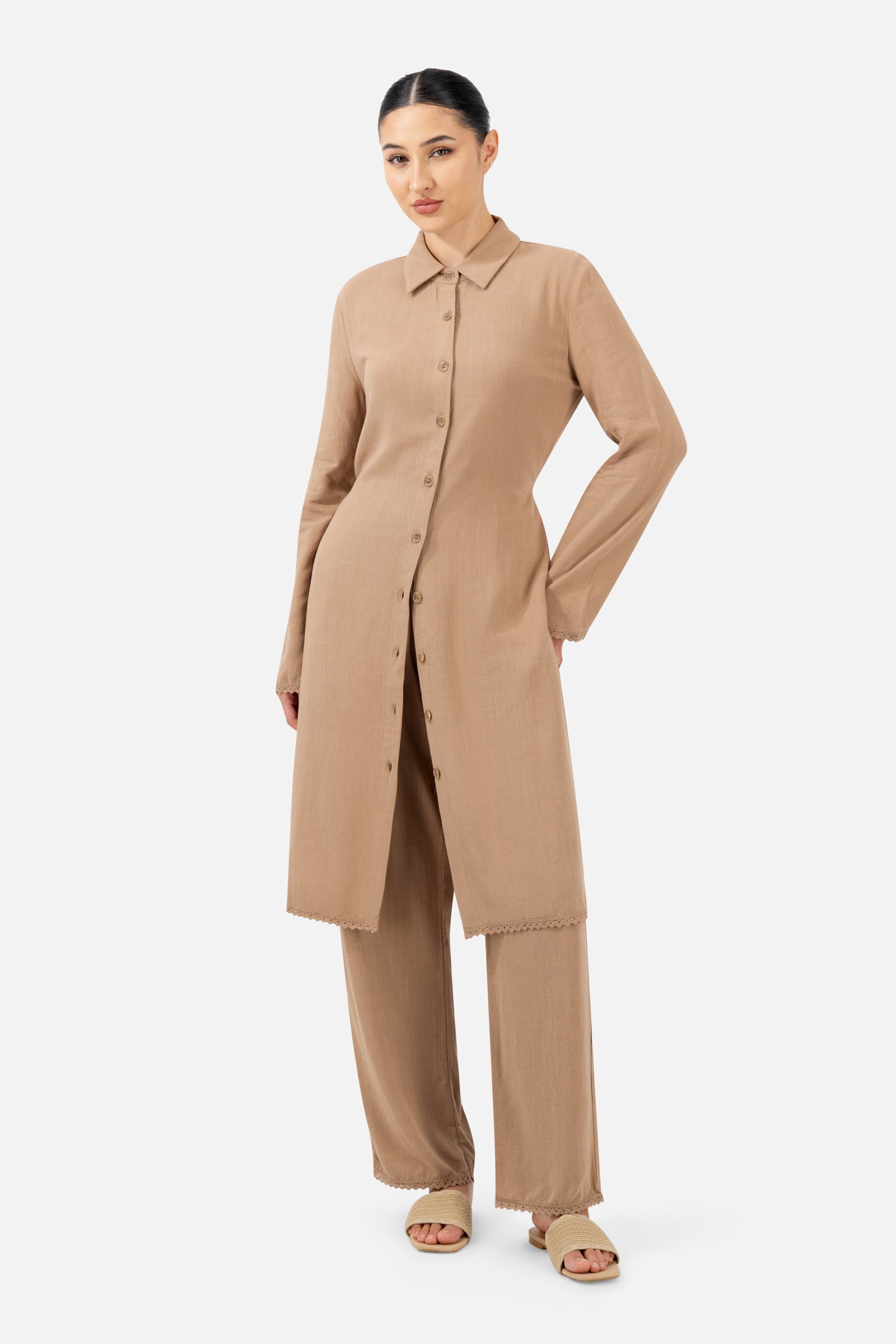 Full-length view of the model wearing the Brownstone Lace Trim Longline Button-Up with matching trousers.