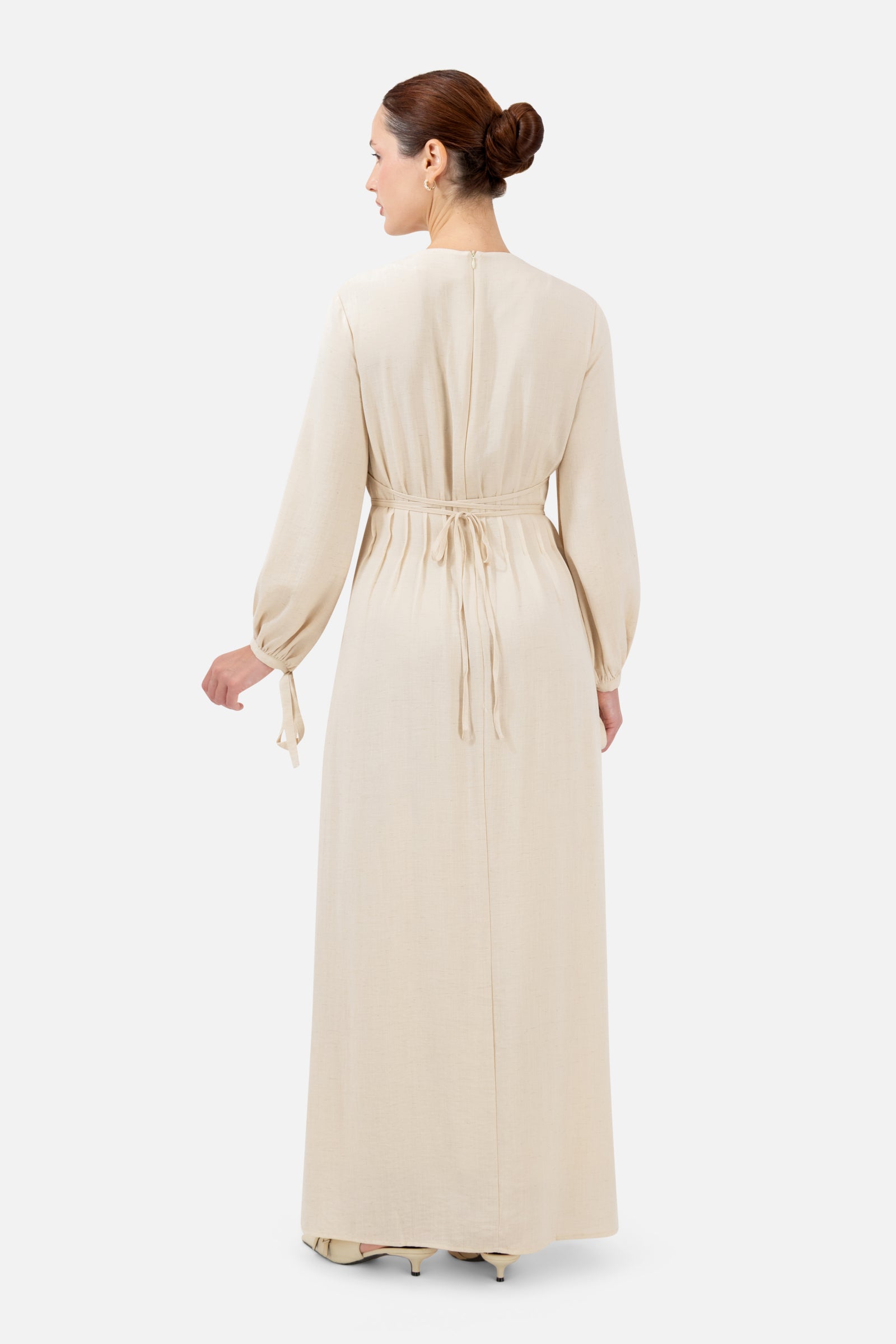 Back view of the Crema tie waist dress showcasing the elegant full-length design.