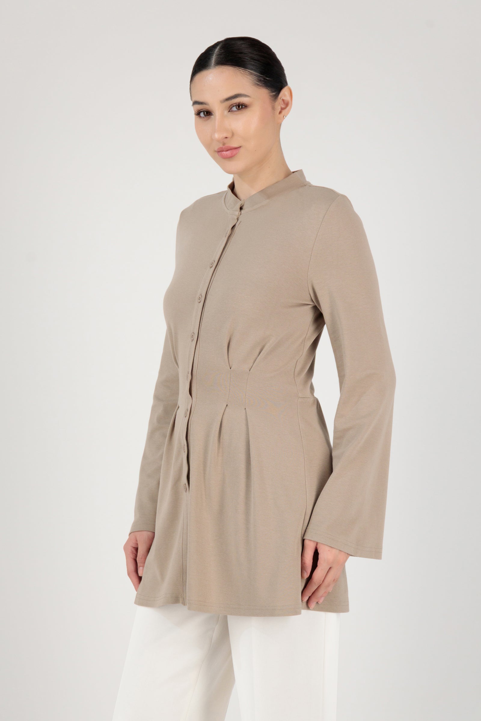 Side angle of the FARES Tailored Knit Tunic in Truffle presenting an elegant tunic shape defined by subtle structure and button-up detailing.