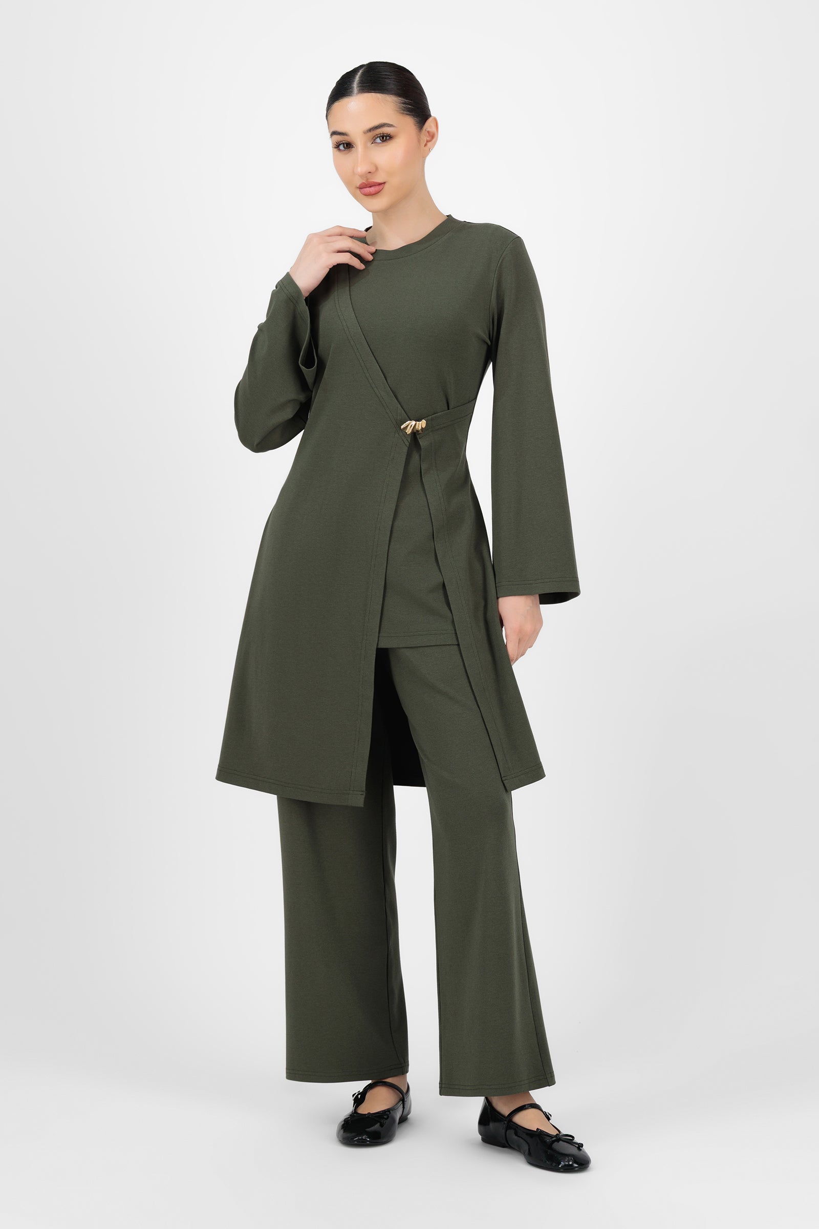 Full-body shot of the model wearing the Evergreen Gold Accent Wrap Top styled with neutral bottoms, showing how easily wrap tops transition from daytime wear to dressed-up evenings.