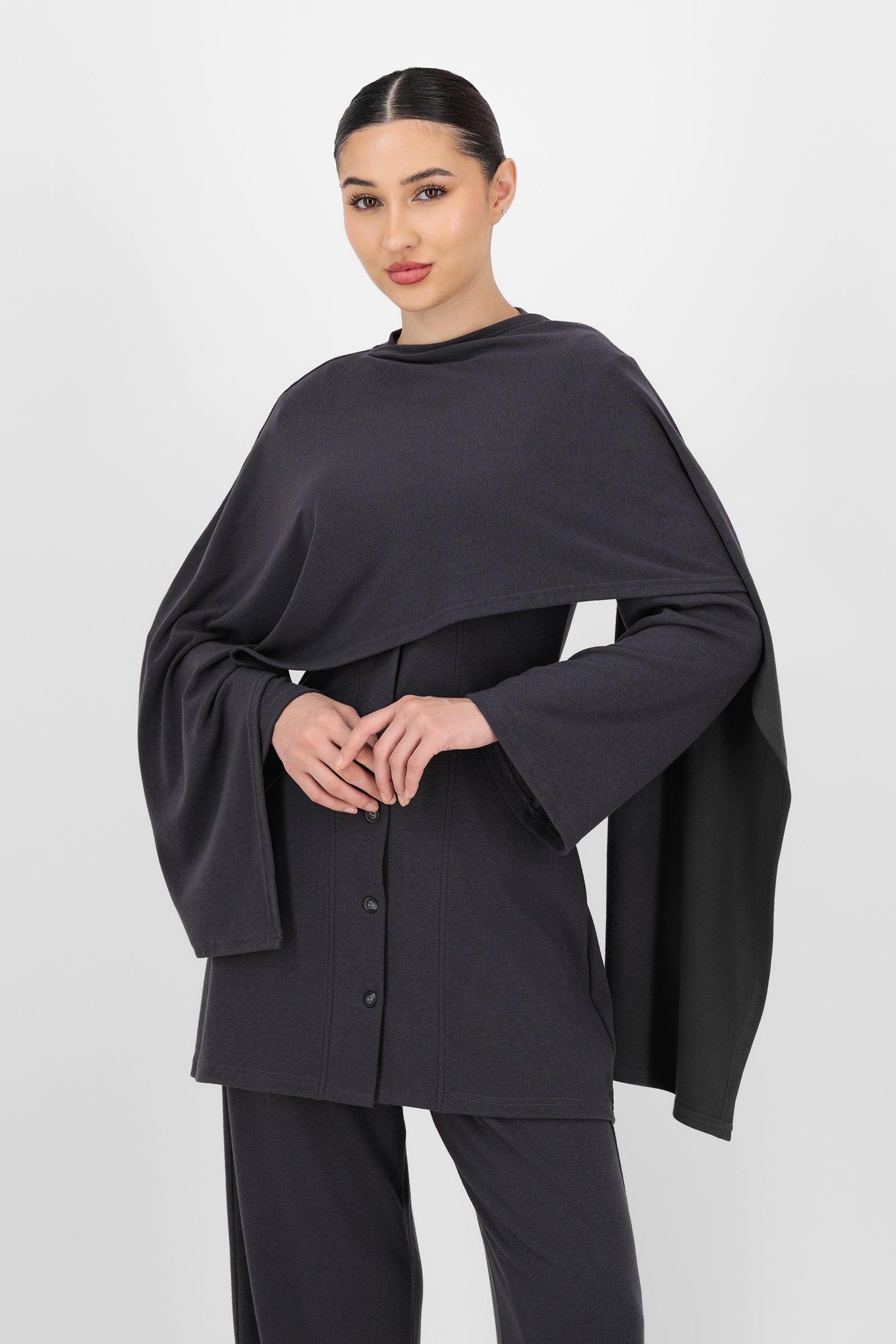 Another front pose of the Charcoal Draped Shawl Knit Top showing the gentle wrap-like shape and comfortable fit that elevate this style within knit tops.