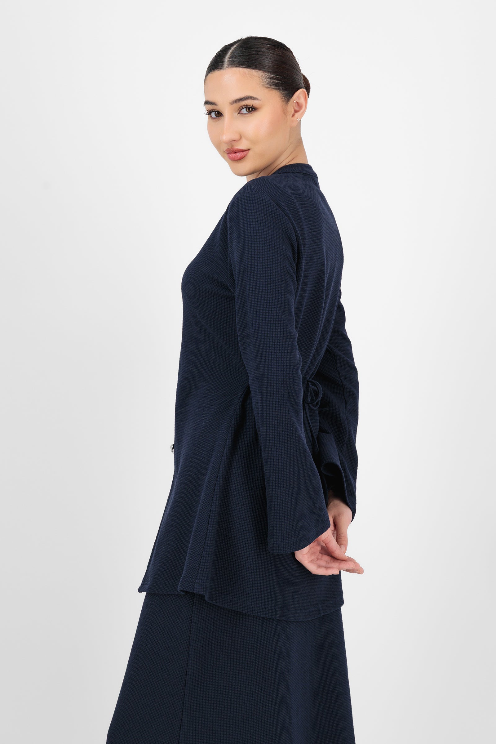 Side angle of the Tailored Vintage Cardigan Navy capturing the tailored fit, subtle ribbing, and classic long cardigan shape that gives it a vintage-inspired feel.