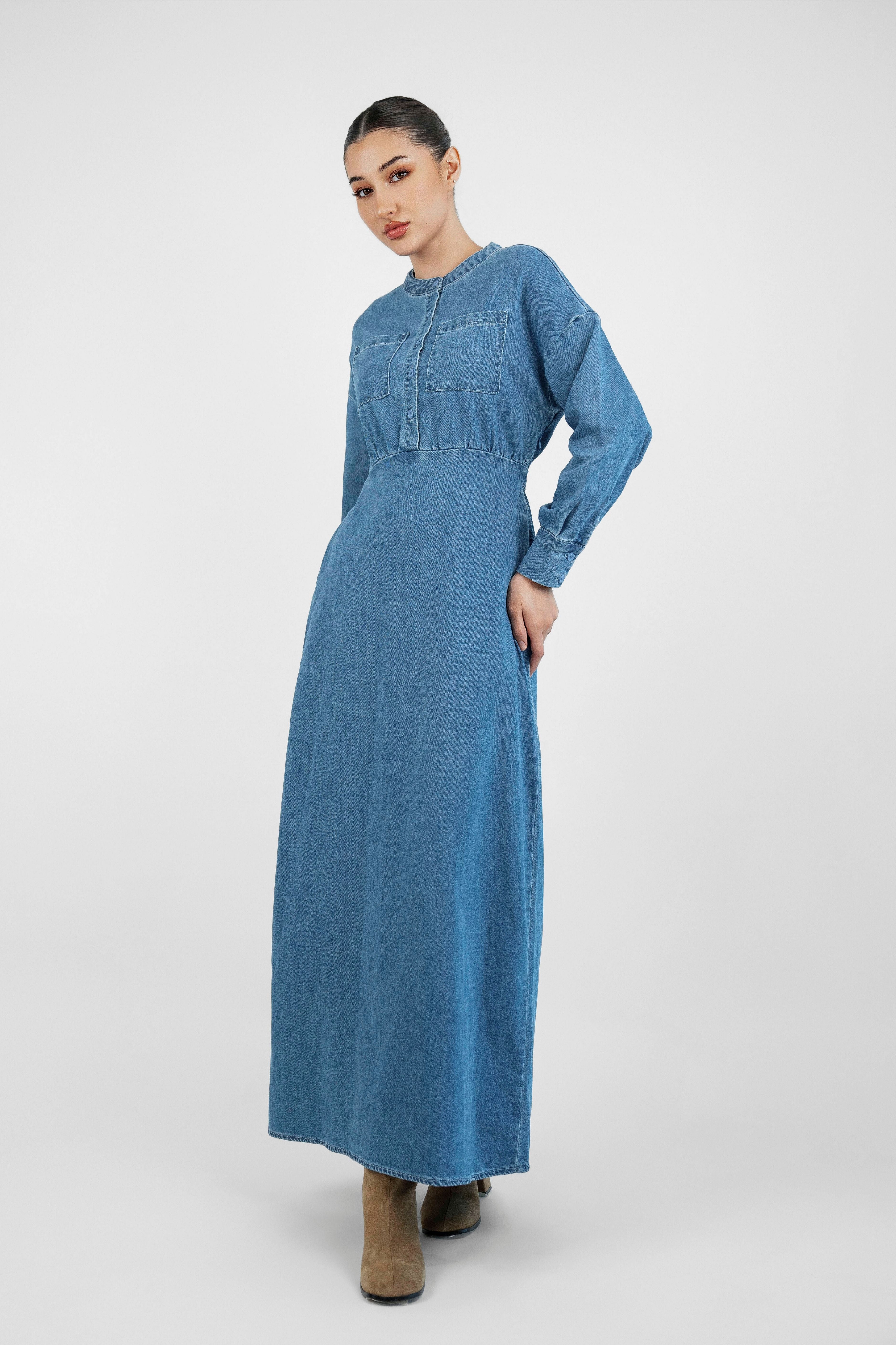 A girl standing in a pose in FARES' denim dress. Colour description: Blue.