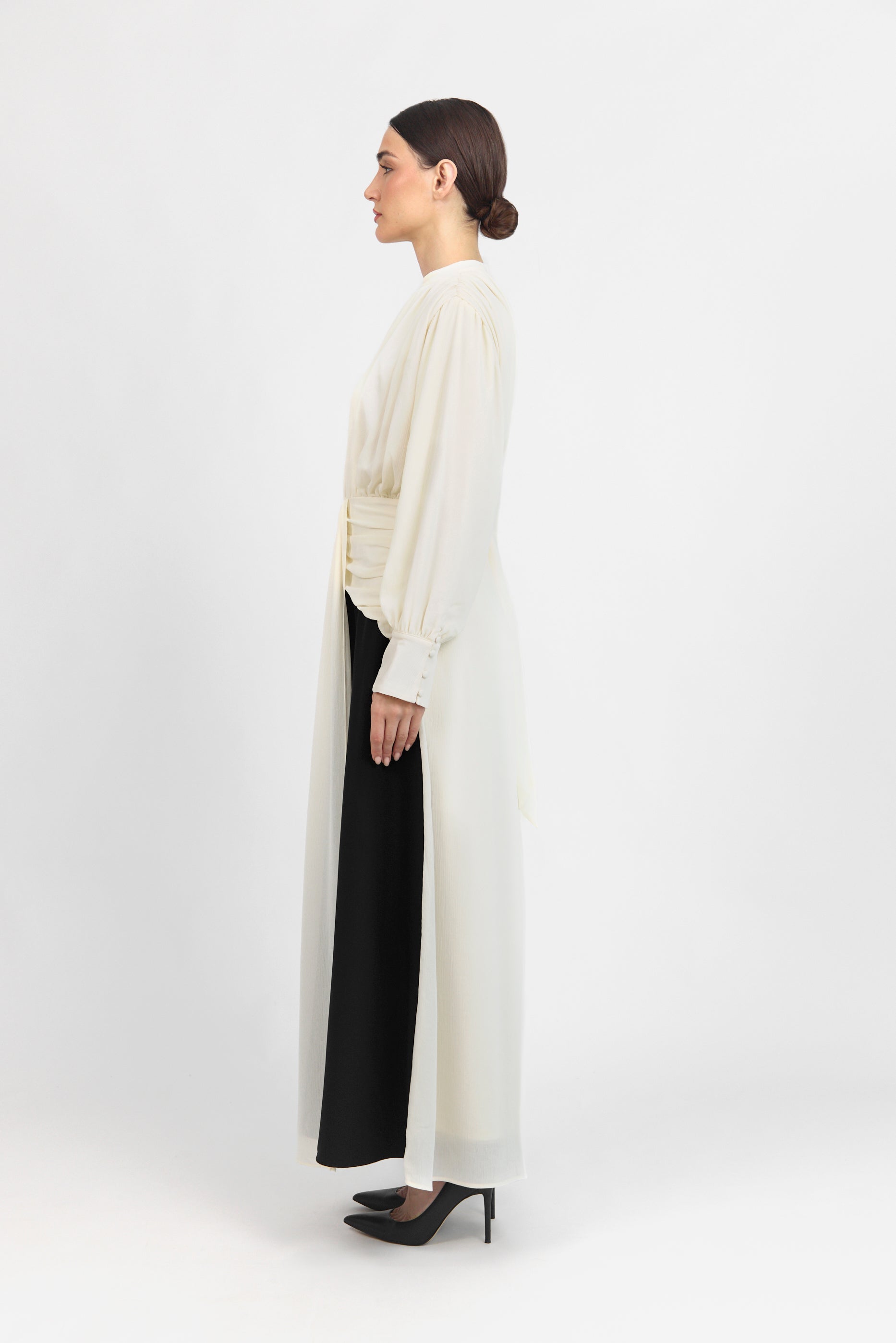 A side look of the model wearing a Contrast Pleated Statement Dress