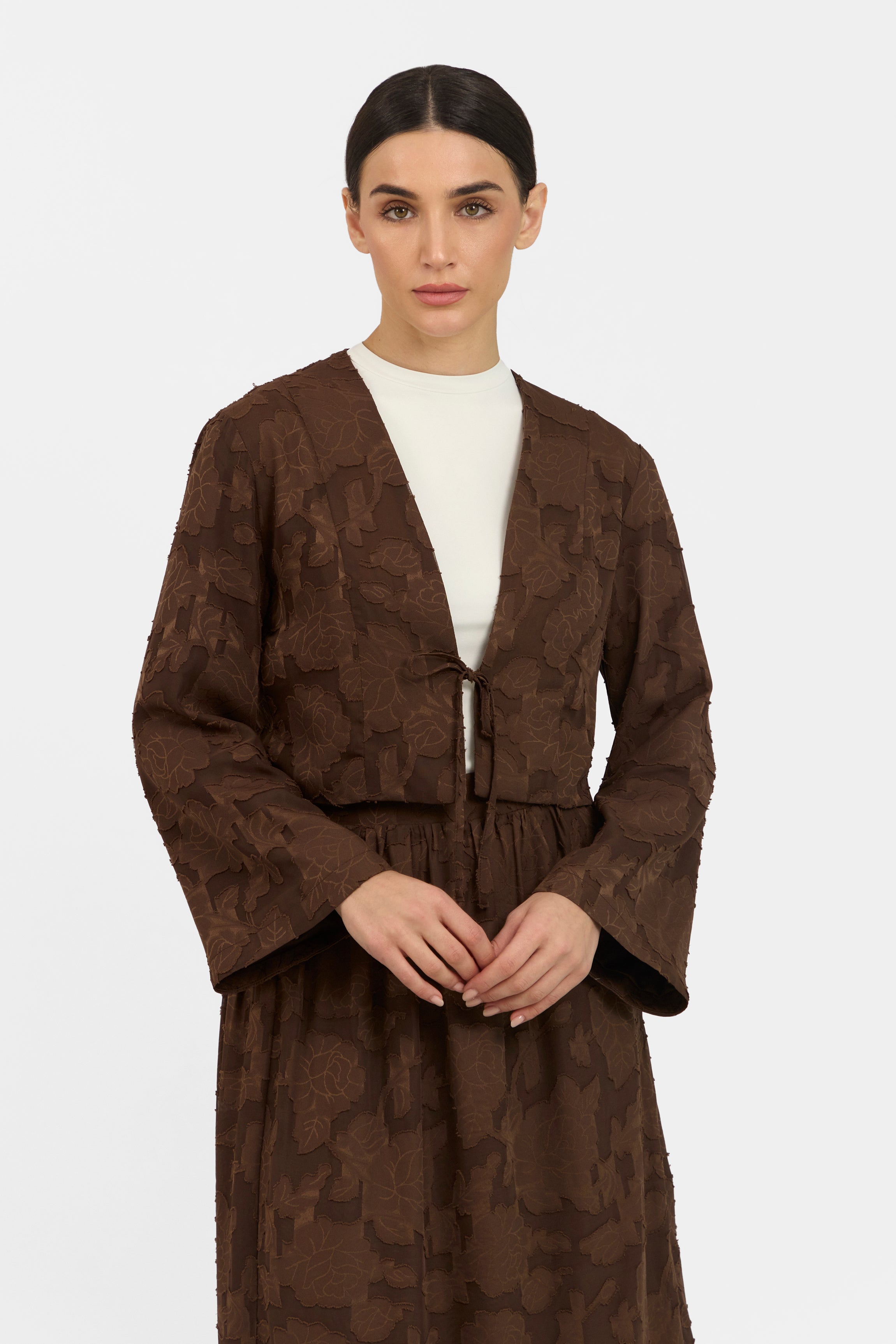 A close up of a model ina  front pose wearing a Floral Cut Out Cropped Cardigan and Skirt Set. Colour: Chocolate