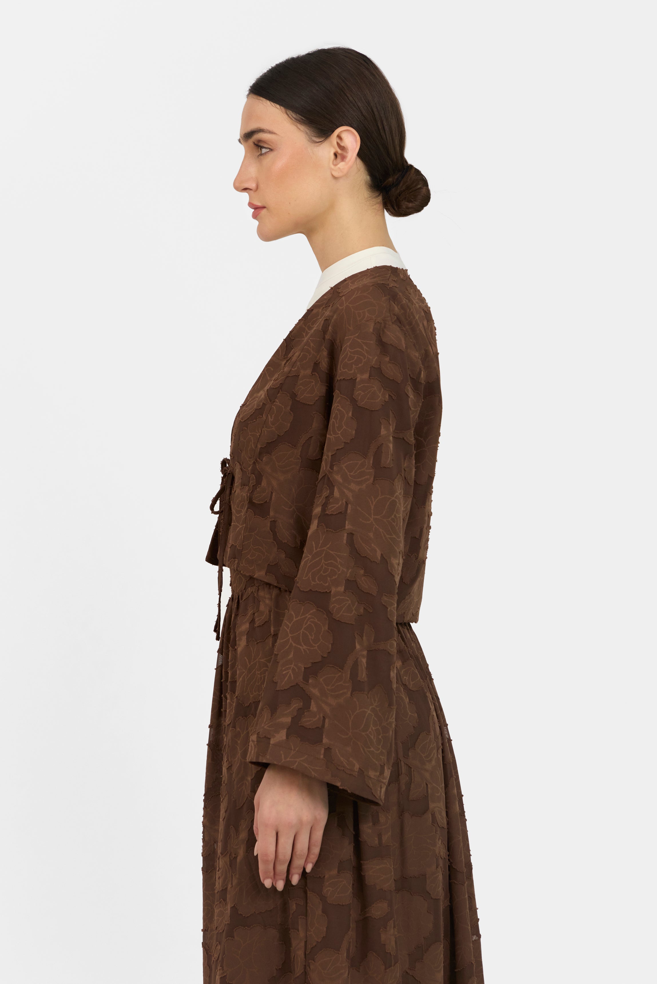 A side pose from a model wearing a Floral Cut Out Cropped Cardigan and Skirt Set 	Colour: Chocolate