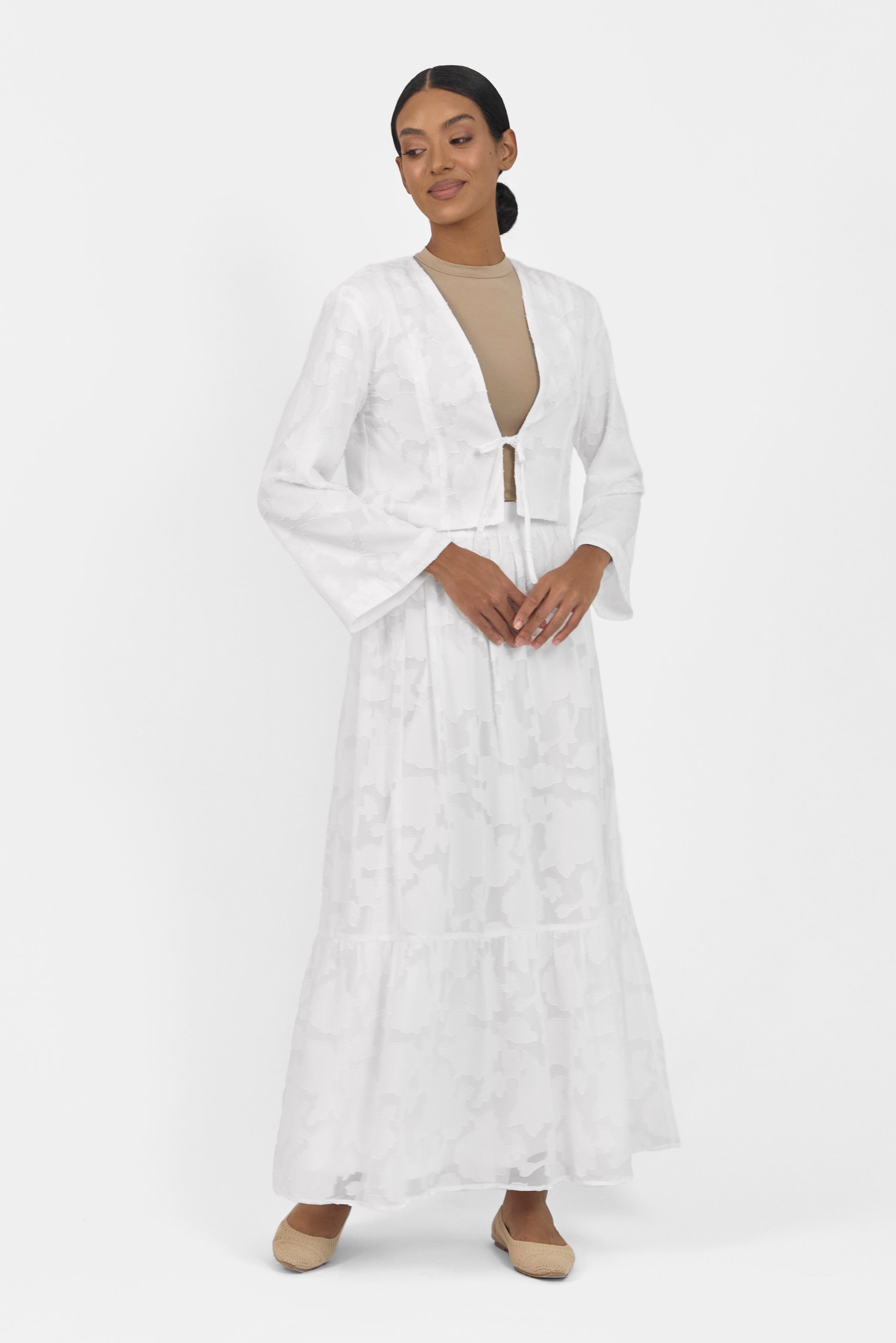 A gir is posing in a Floral Cut Out Cropped Cardigan and Skirt Set. Colour: White