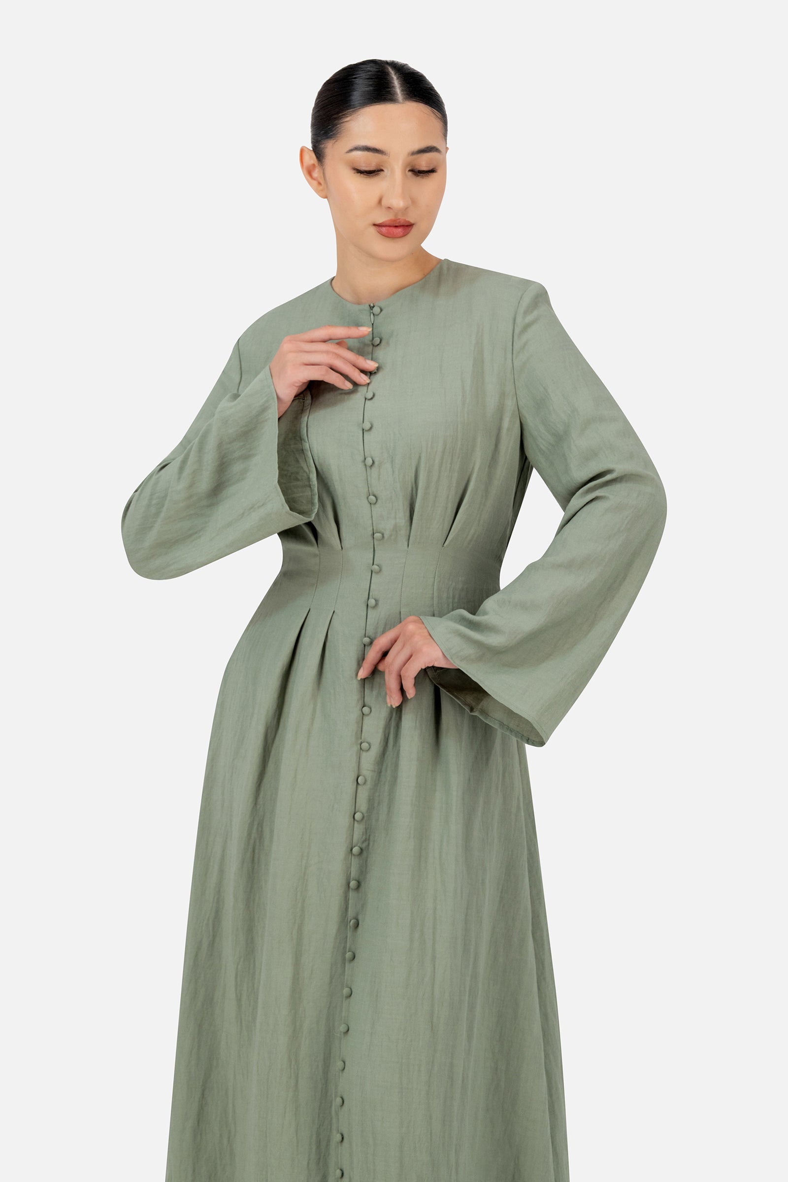 Woman styling the FARES Tailored Waist Button Front Dress in Clover featuring decorative buttons and a softly structured silhouette for elegant maxi dresses for women.