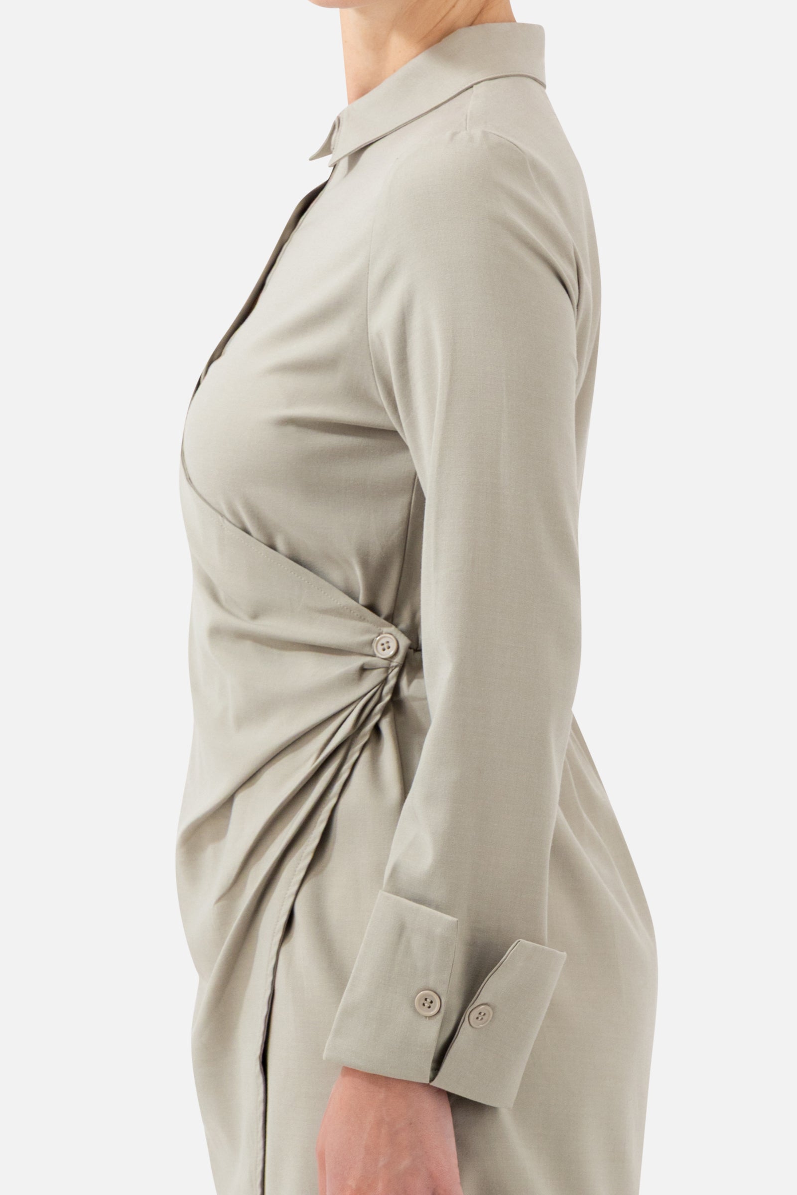 Close-up of the wrap detail and side gathering on the Antique Green long-sleeve top.
