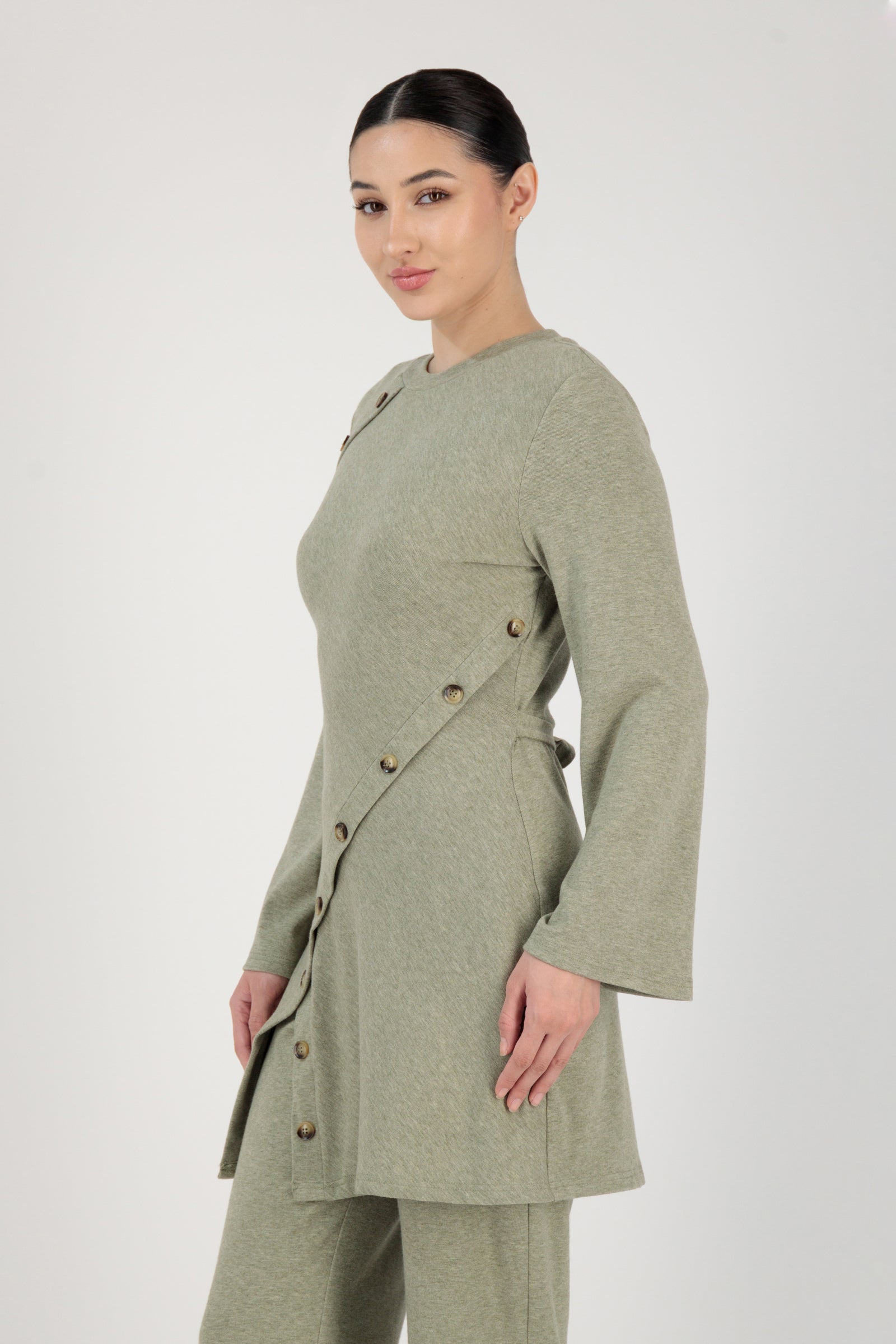 Side angle of the FARES Button Detail Knit Tunic in Olive presenting an elegant tunic shape with subtle structure.