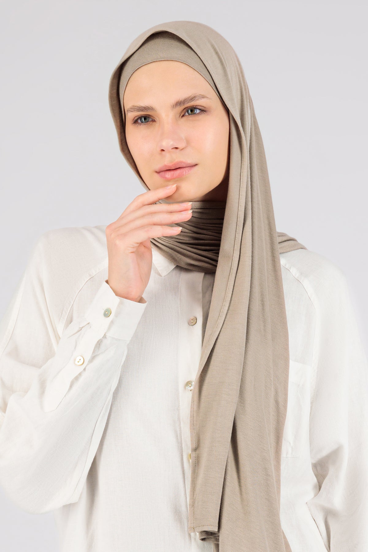 The front of a female model wearing a matching jersey hijab set. Colour description: light beige. This set includes a modal jersey hijab and matching undercap.