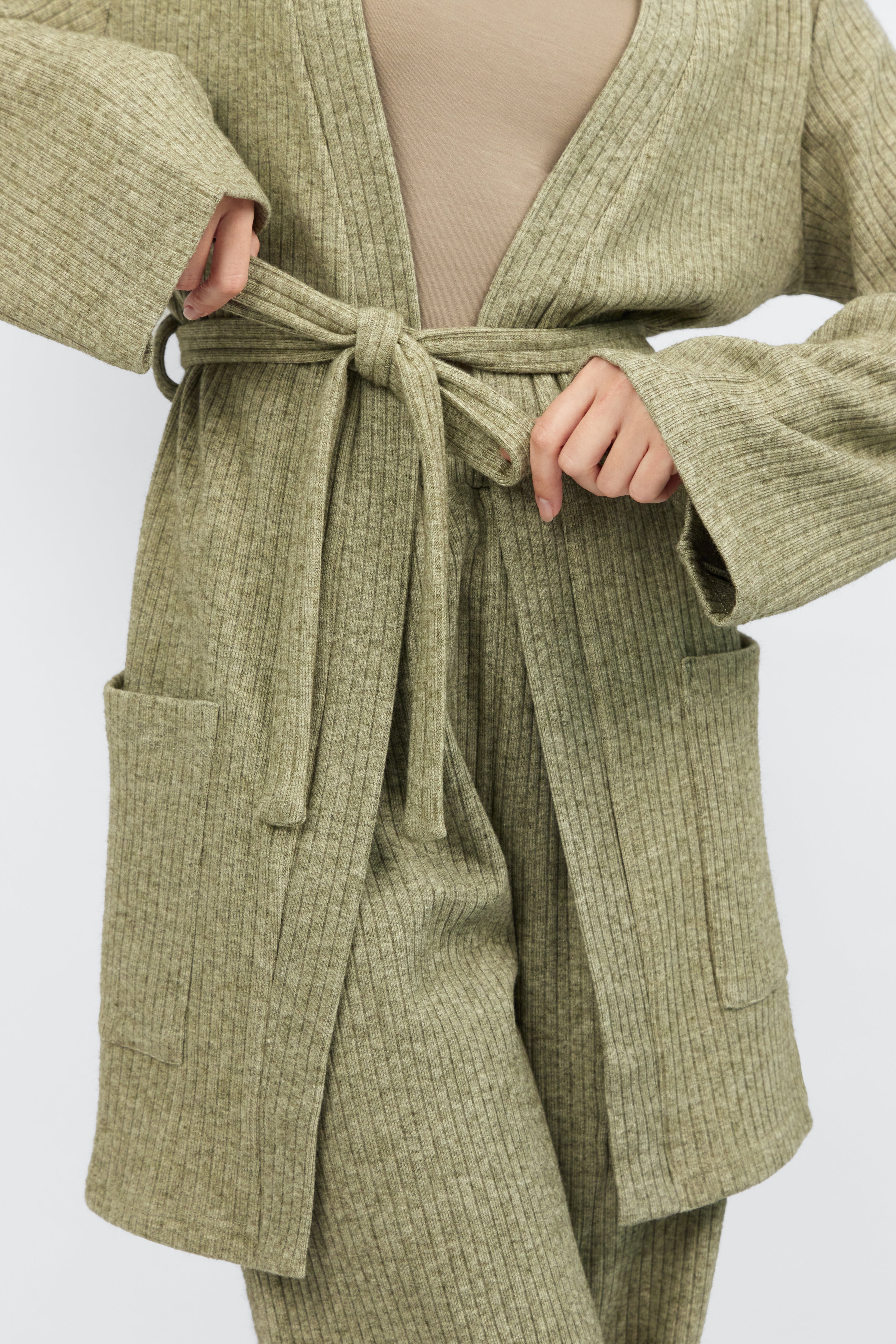 A close up of the cardigan with belt from FARES. Colour description: Muted Green.