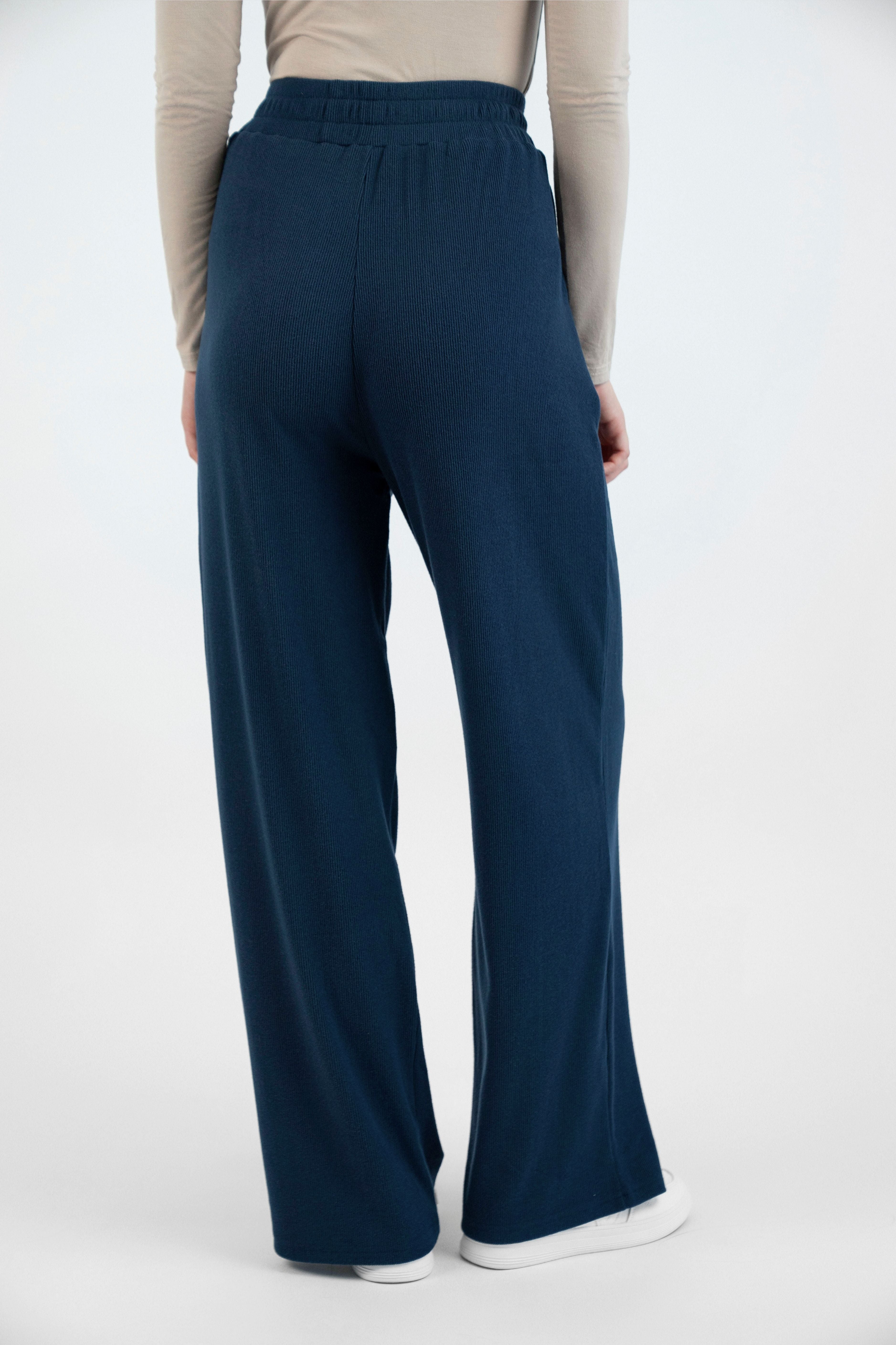 Colour description: Navy Blue. FARES' velour pants are shown from the back.