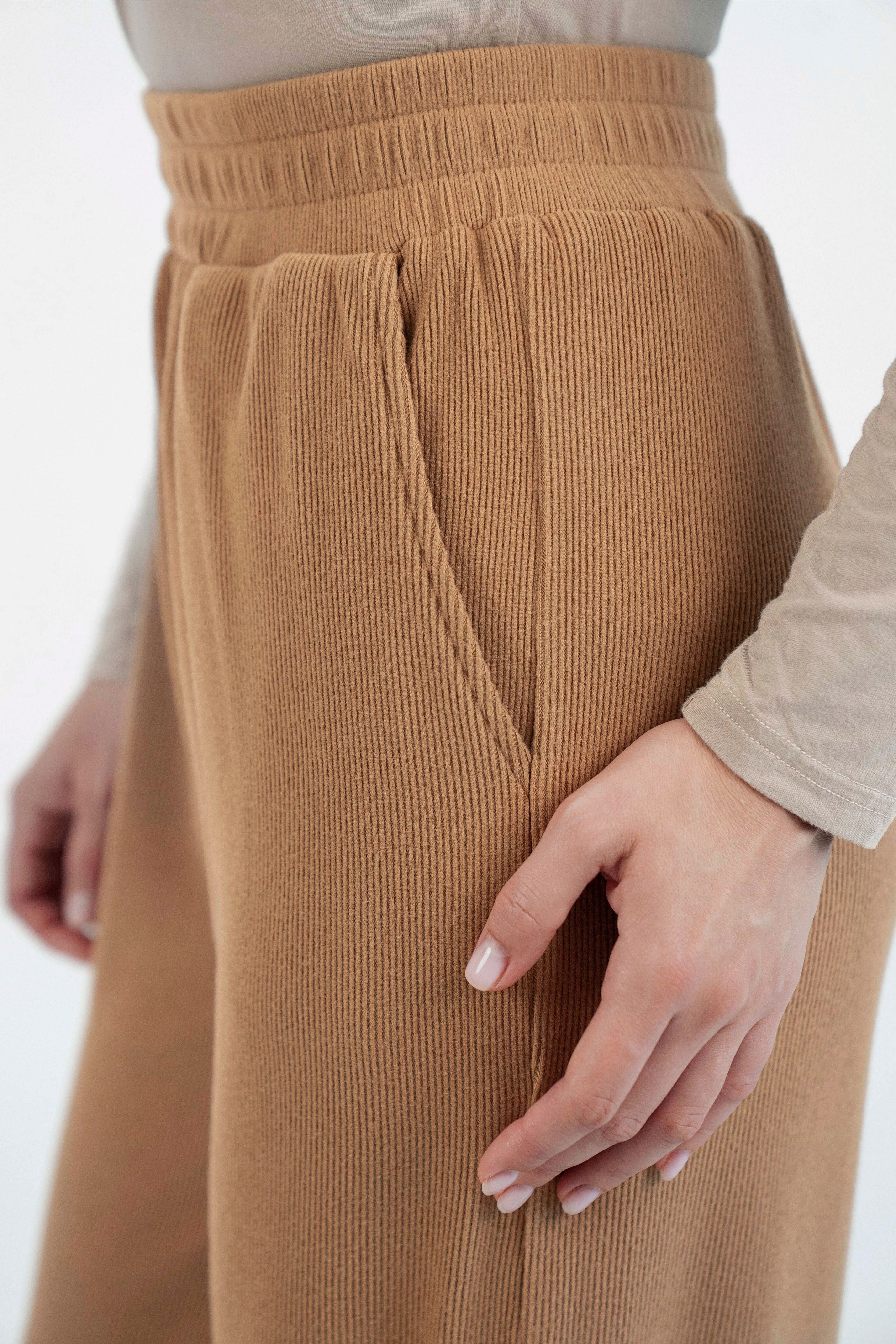 Colour description: Toffee. A close up of the pocket of these wide leg knit pants.
