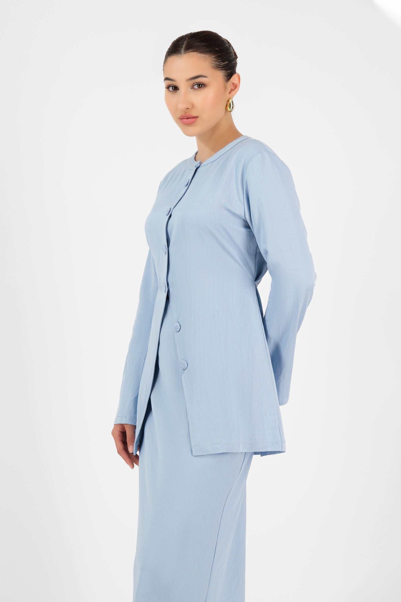Side profile of the FARES Tailored Vintage Lightweight Cardigan in Powder Blue, showing the flowy hemline and tailored fit for modern cardigan women.