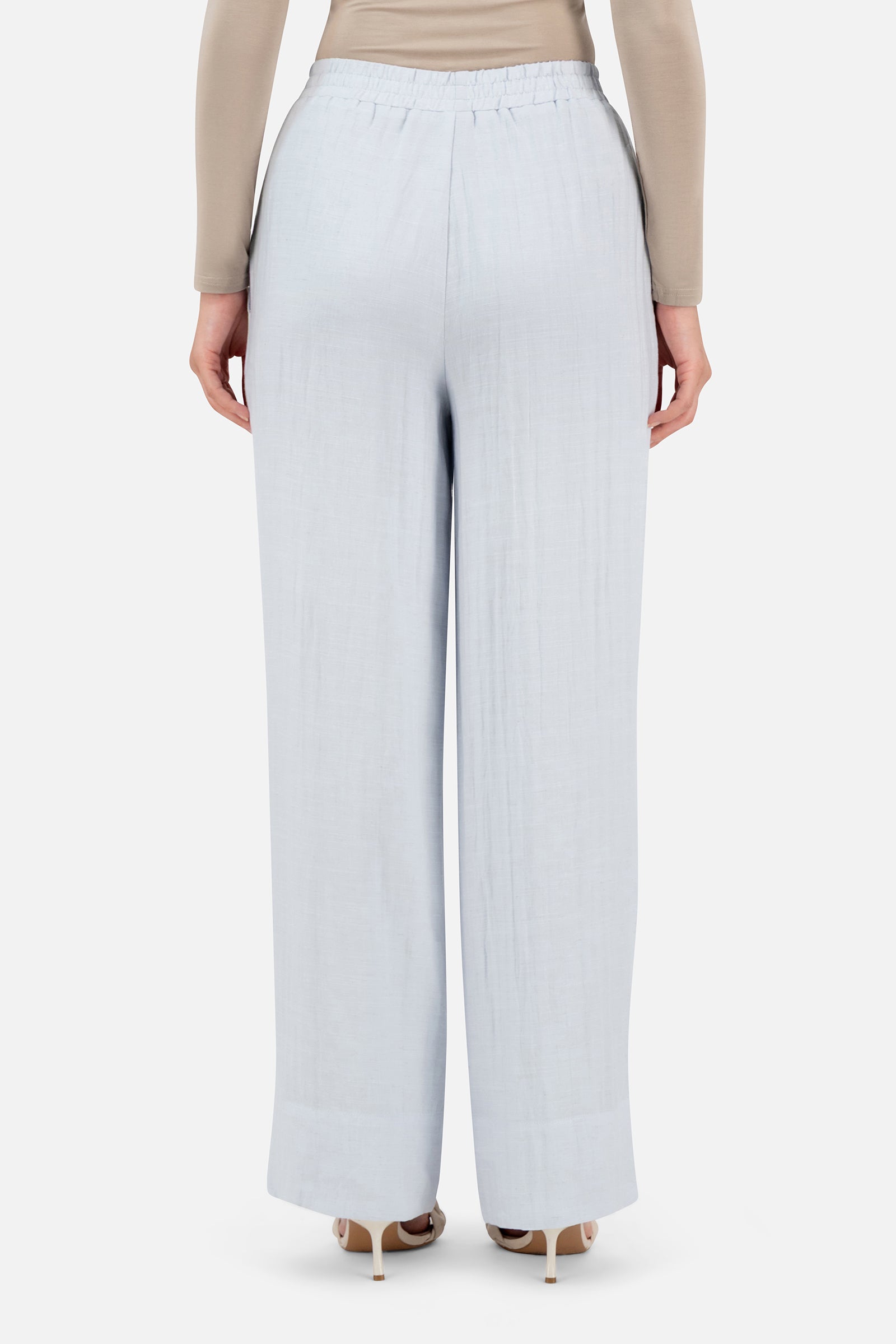 Back view of a woman wearing the Blueberry Cream FARES pants for women showcasing the relaxed fit and clean tailored finish.