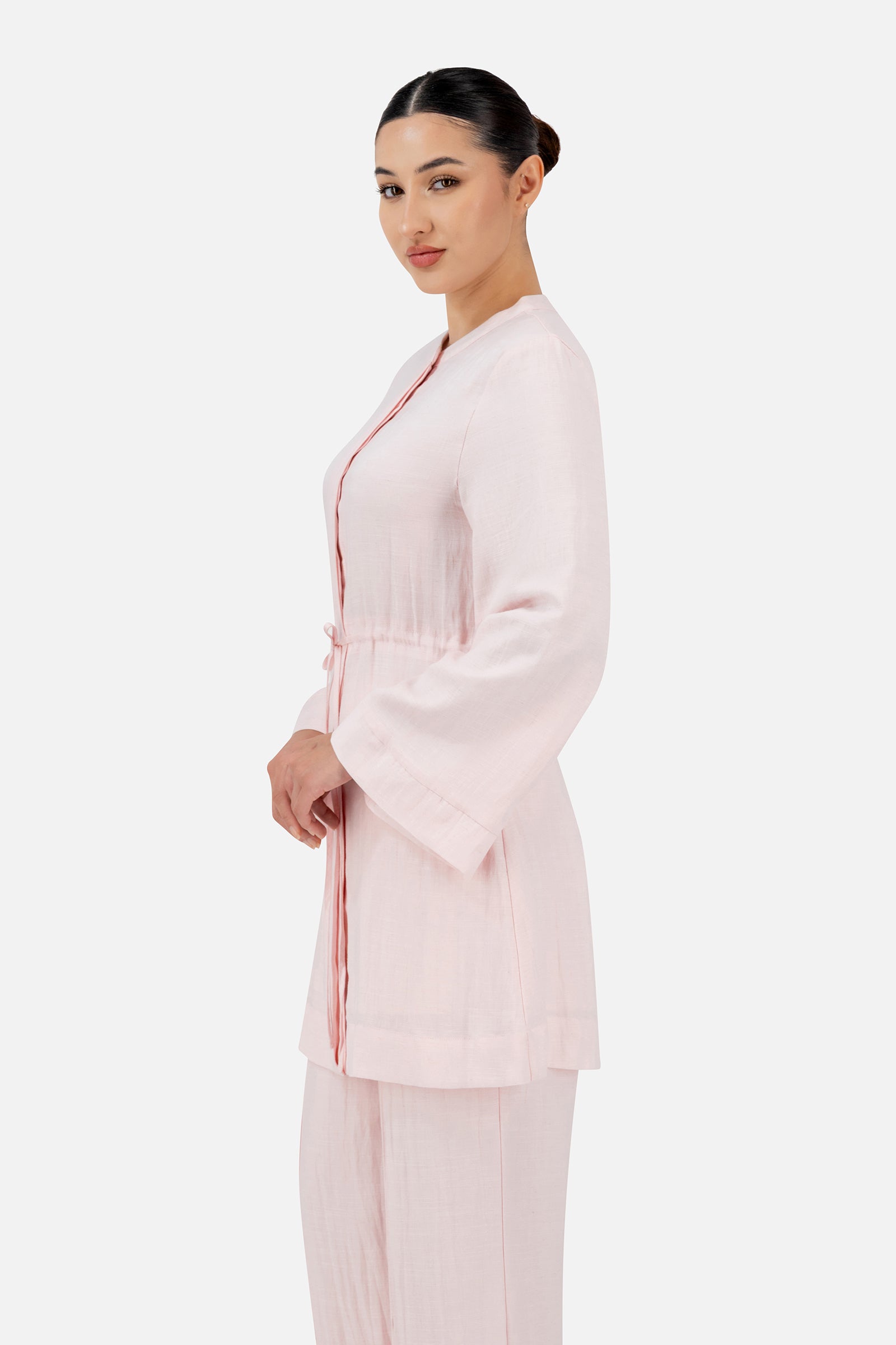 Side profile of the FARES Drawstring Waist Button Up in Strawberry Cream highlighting the clean button-up inspired silhouette and wide sleeves.