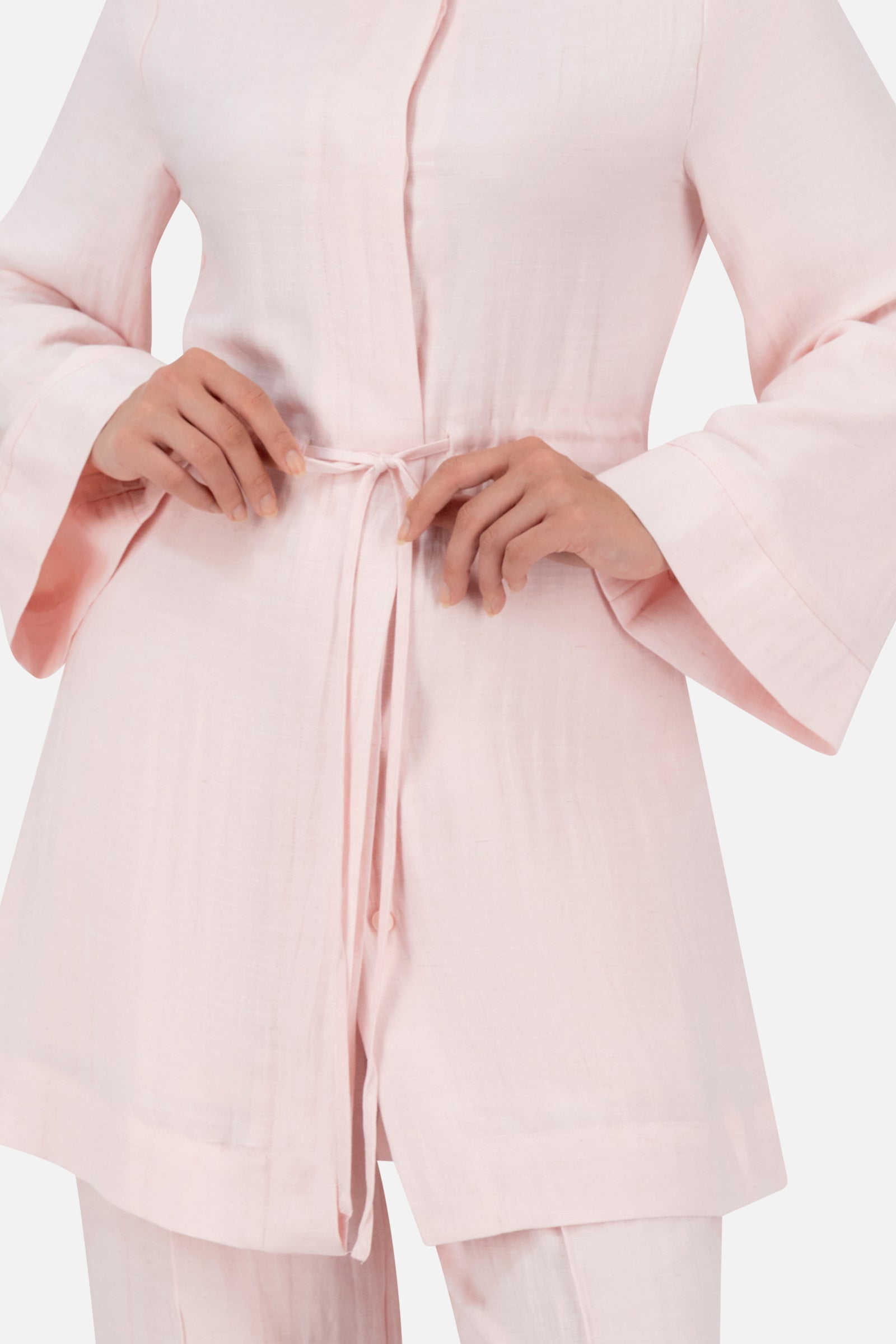 Close-up of the FARES Drawstring Waist Button Up in Strawberry Cream featuring delicate waist ties and refined button-up detailing.