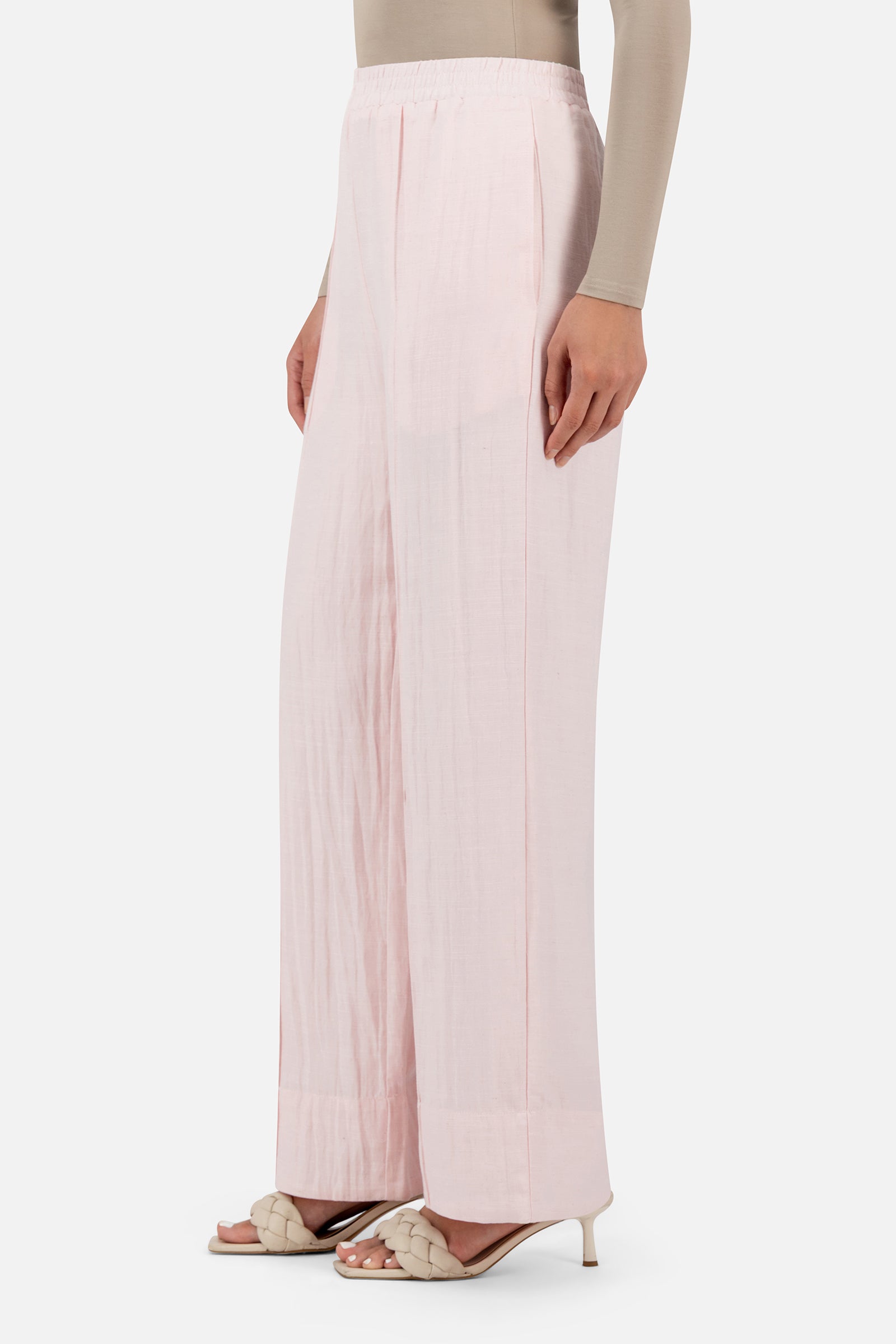 Side profile of the FARES Straight Leg Flowy Pants in Strawberry Cream highlighting the elongated silhouette of the linen pants.