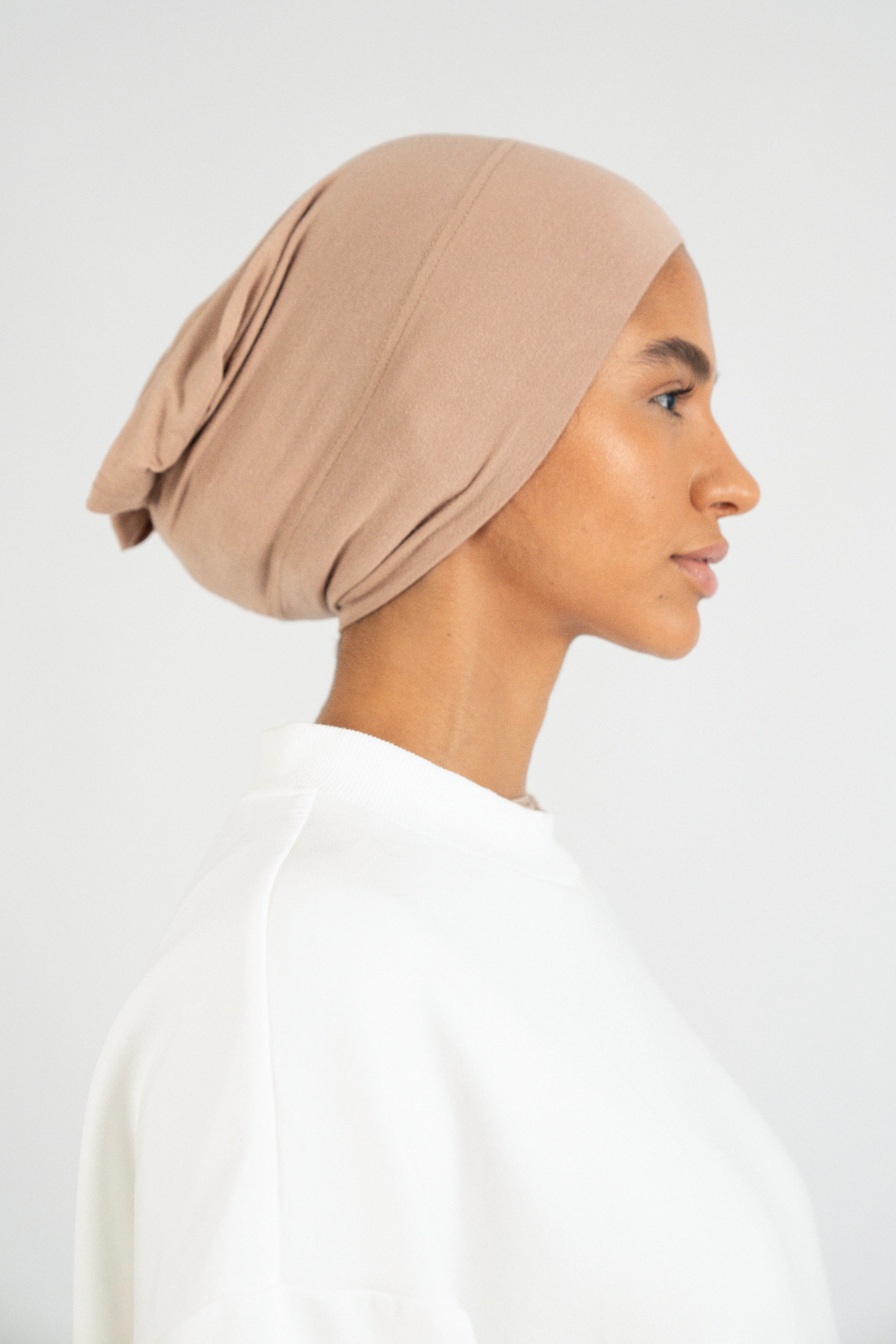 The right profile of a girl wearing a modal hijab undercap. Colour: Almond