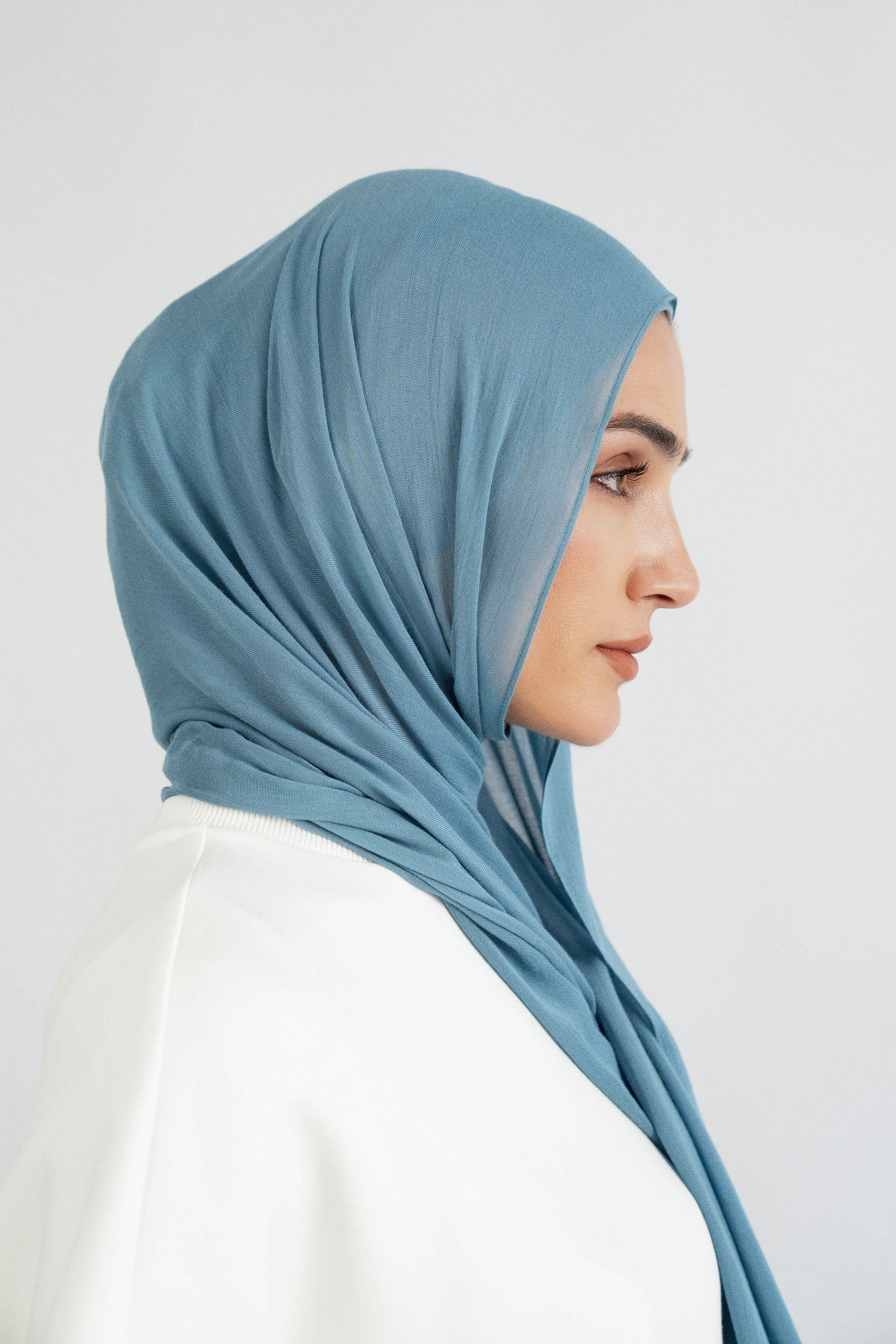 Colour: Marina. A model is turned right in a Matching Butter Modal Hijab Set.