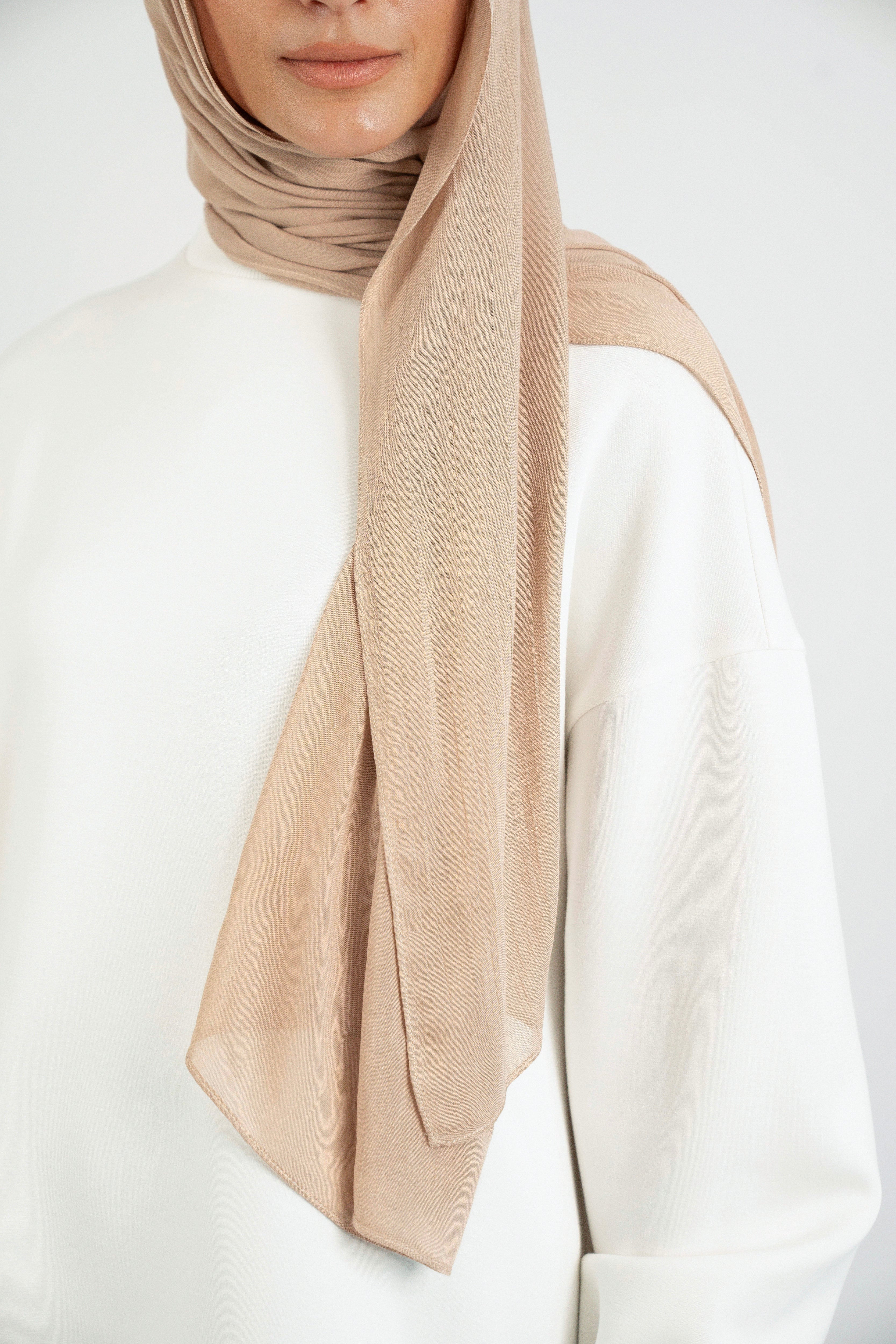 Colour: Biscuit. A close up of the Matching Butter Modal Hijab Set fitting on the shoulder of a model.
