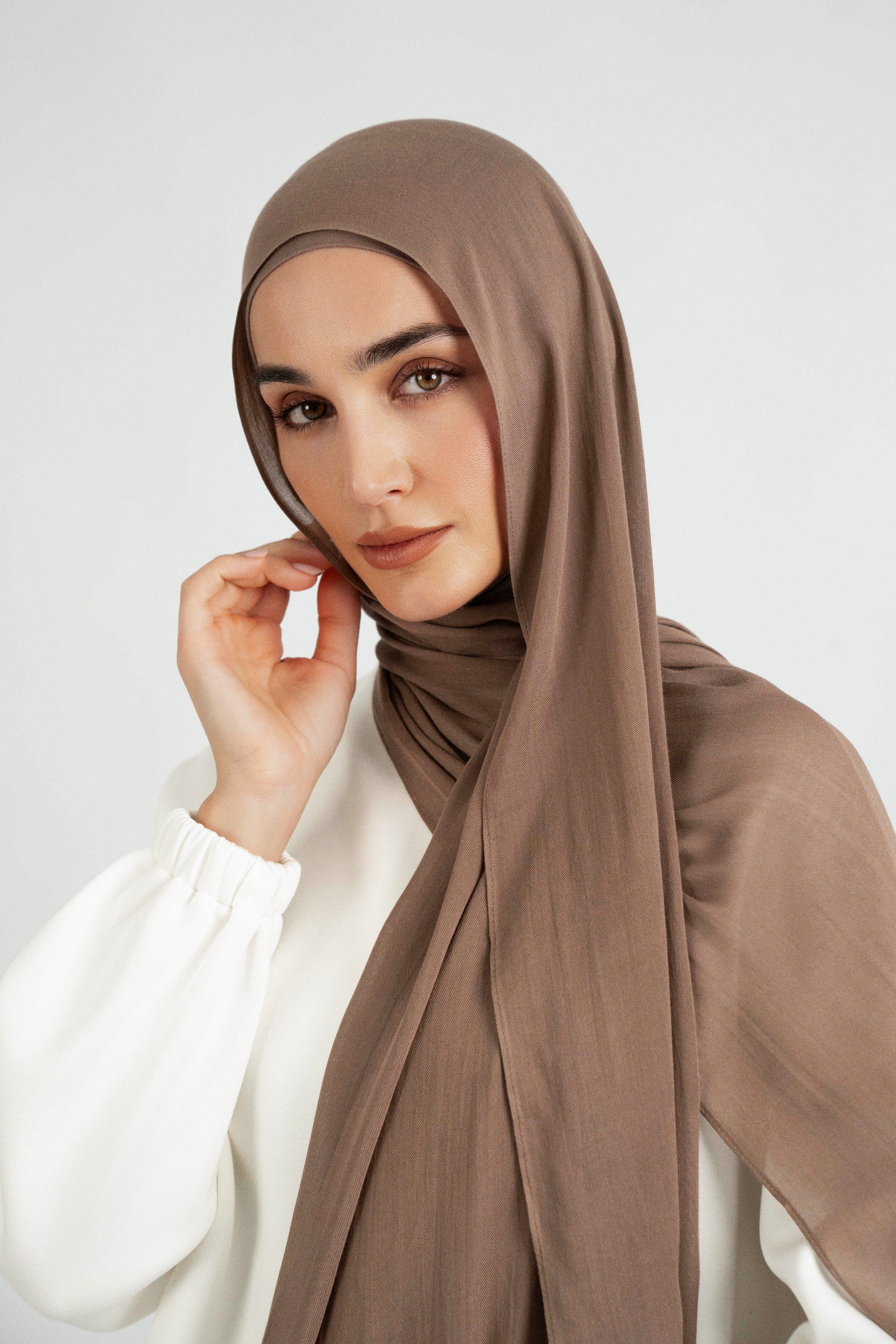 A close up of girl wearing a Matching Butter Modal Hijab Set and touching her face. Colour:  Walnut.