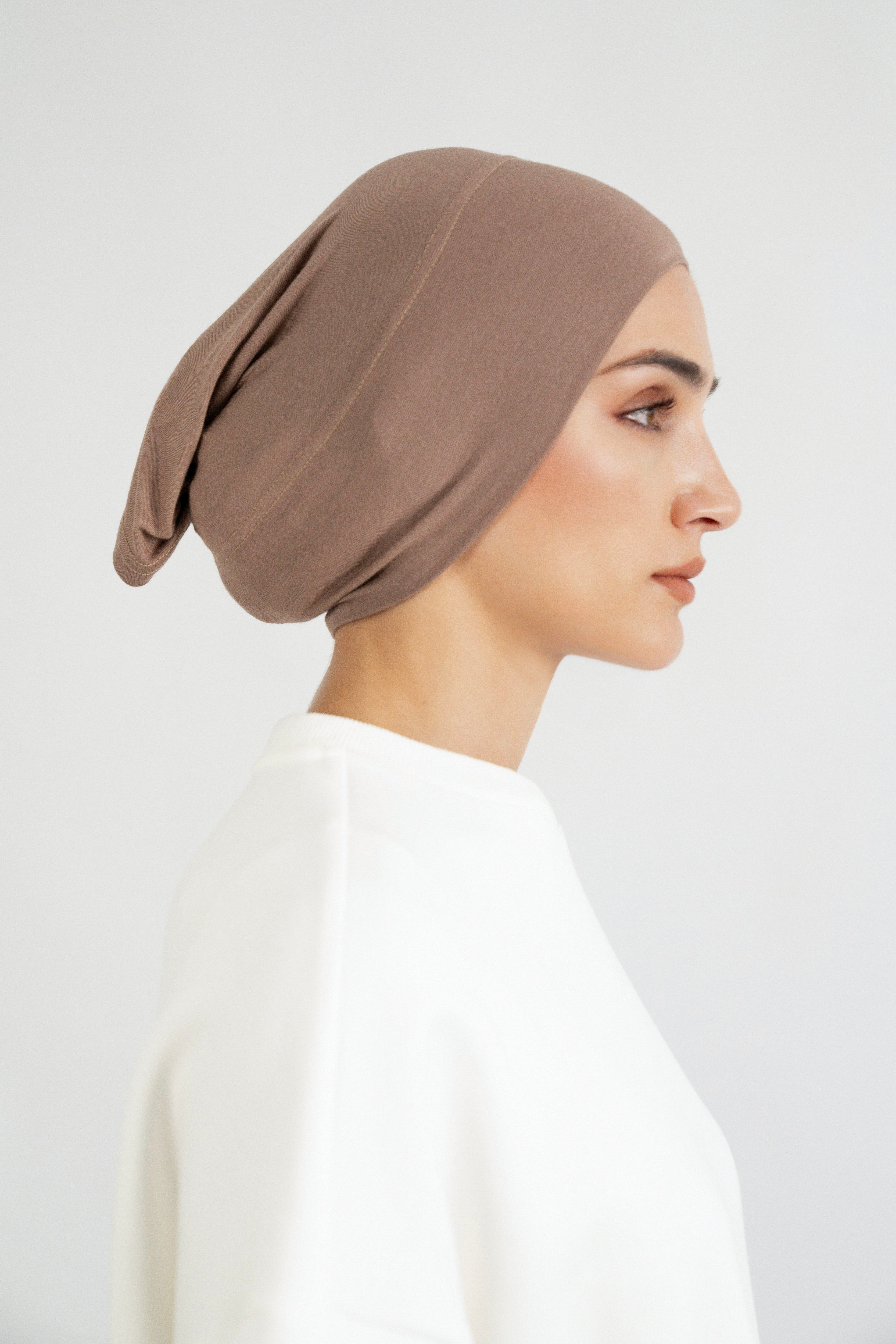 The right profile of a girl wearing a modal hijab undercap. Colour: Walnut.