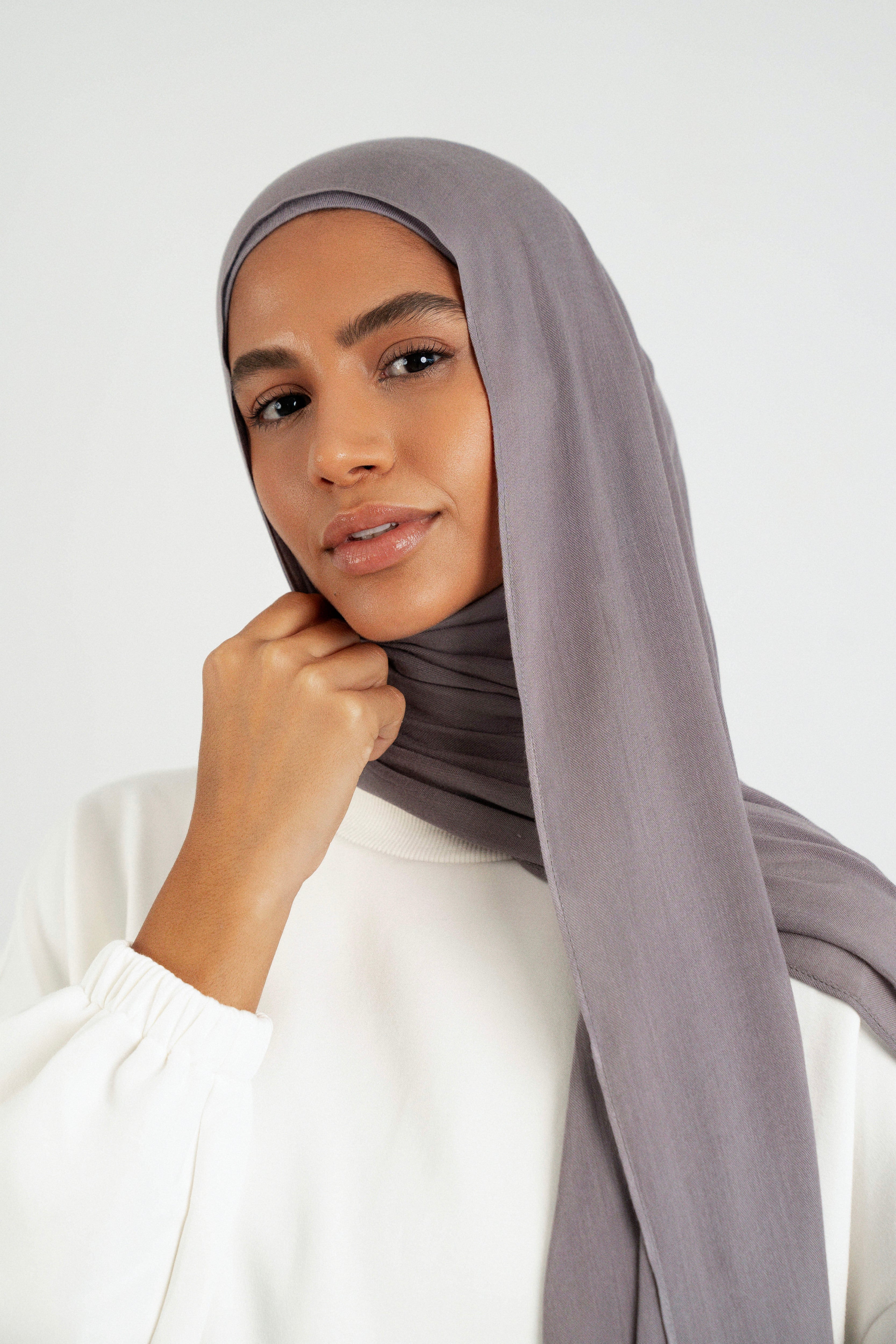 Colour: Moon. A close up of girl wearing a Matching Butter Modal Hijab Set and touching her face.