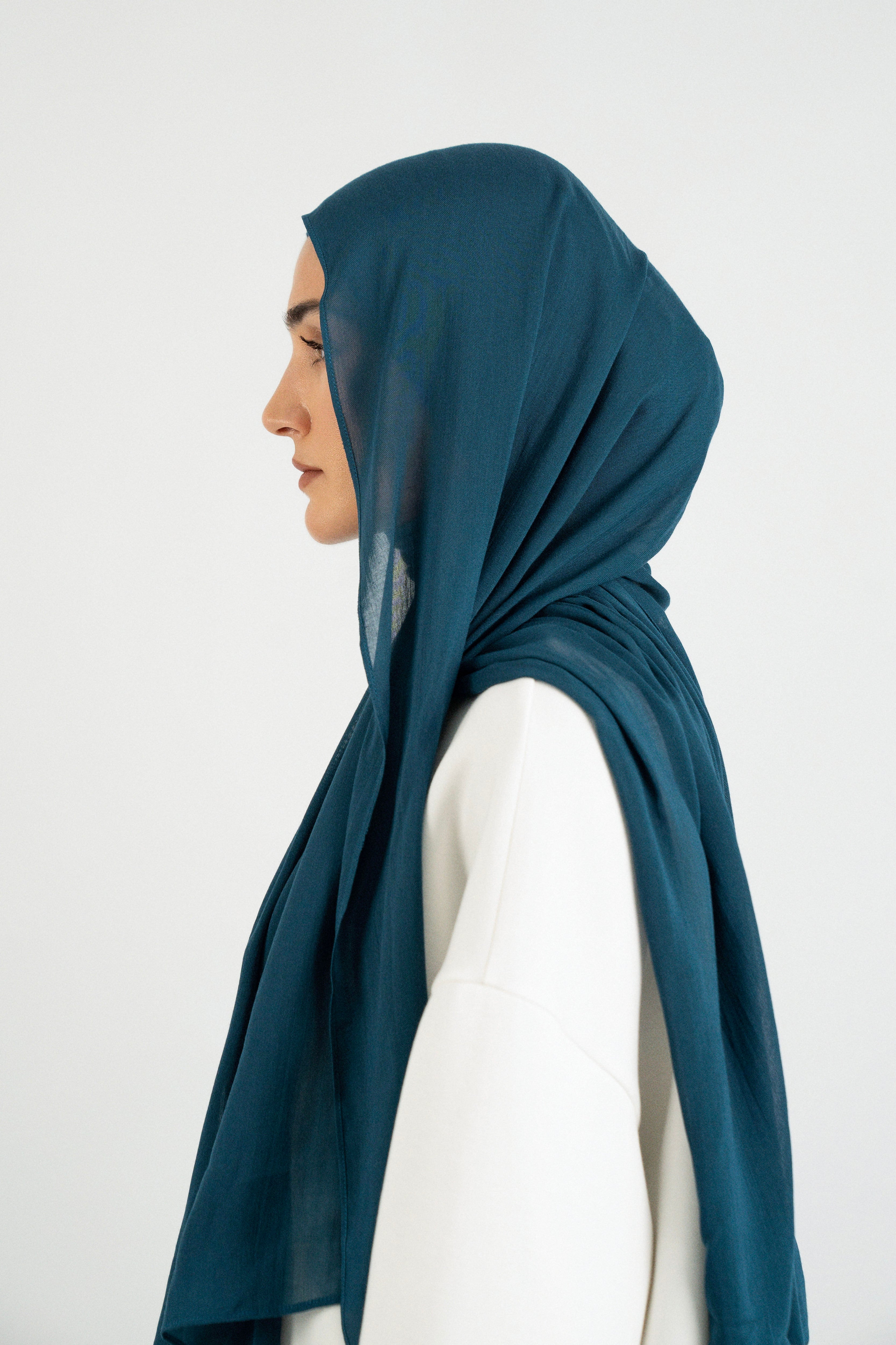 Colour: Real Teal. A woman is turned left in a Matching Butter Modal Hijab Set.