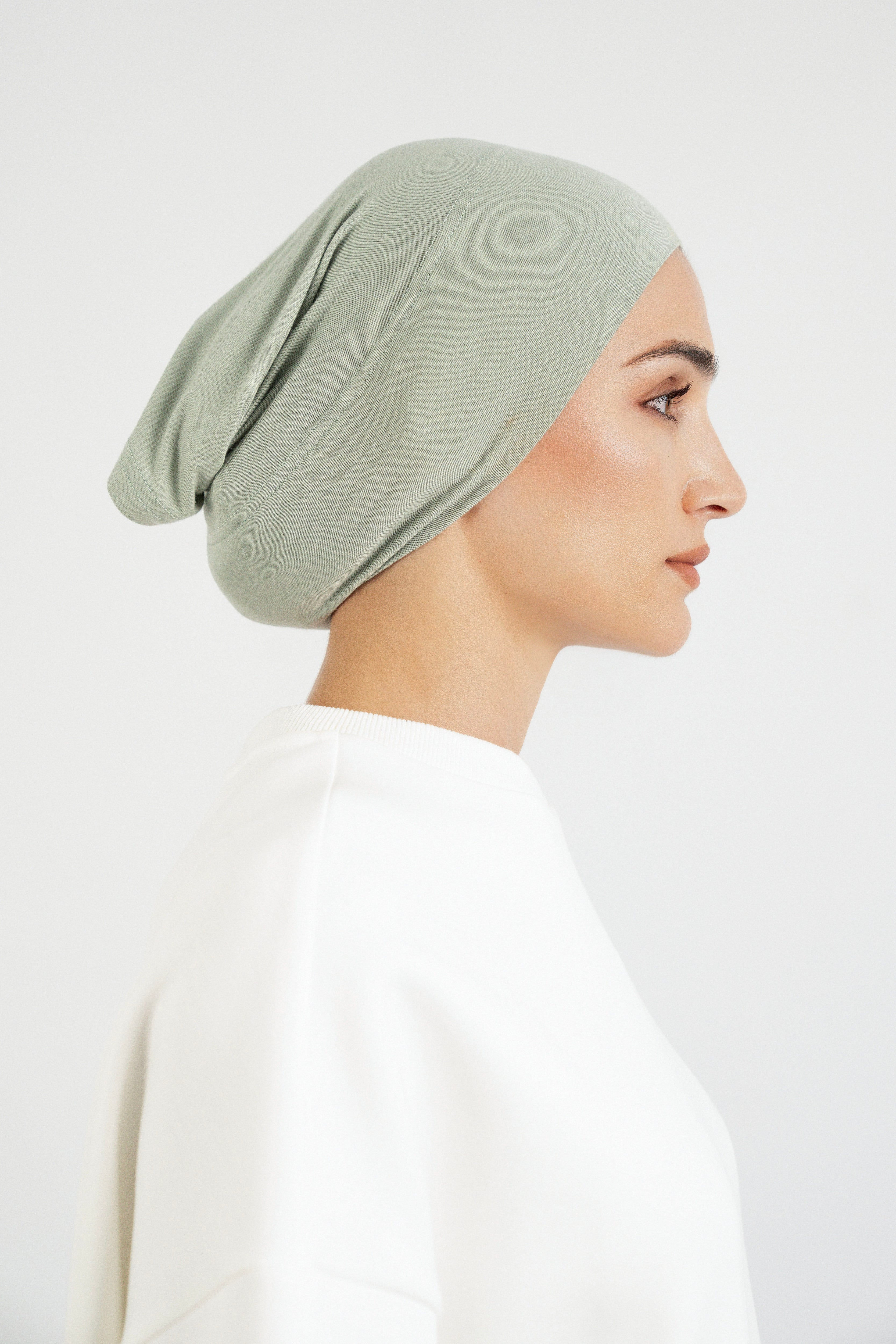 Colour: Sage. The right profile of a model wearing a modal hijab undercap.