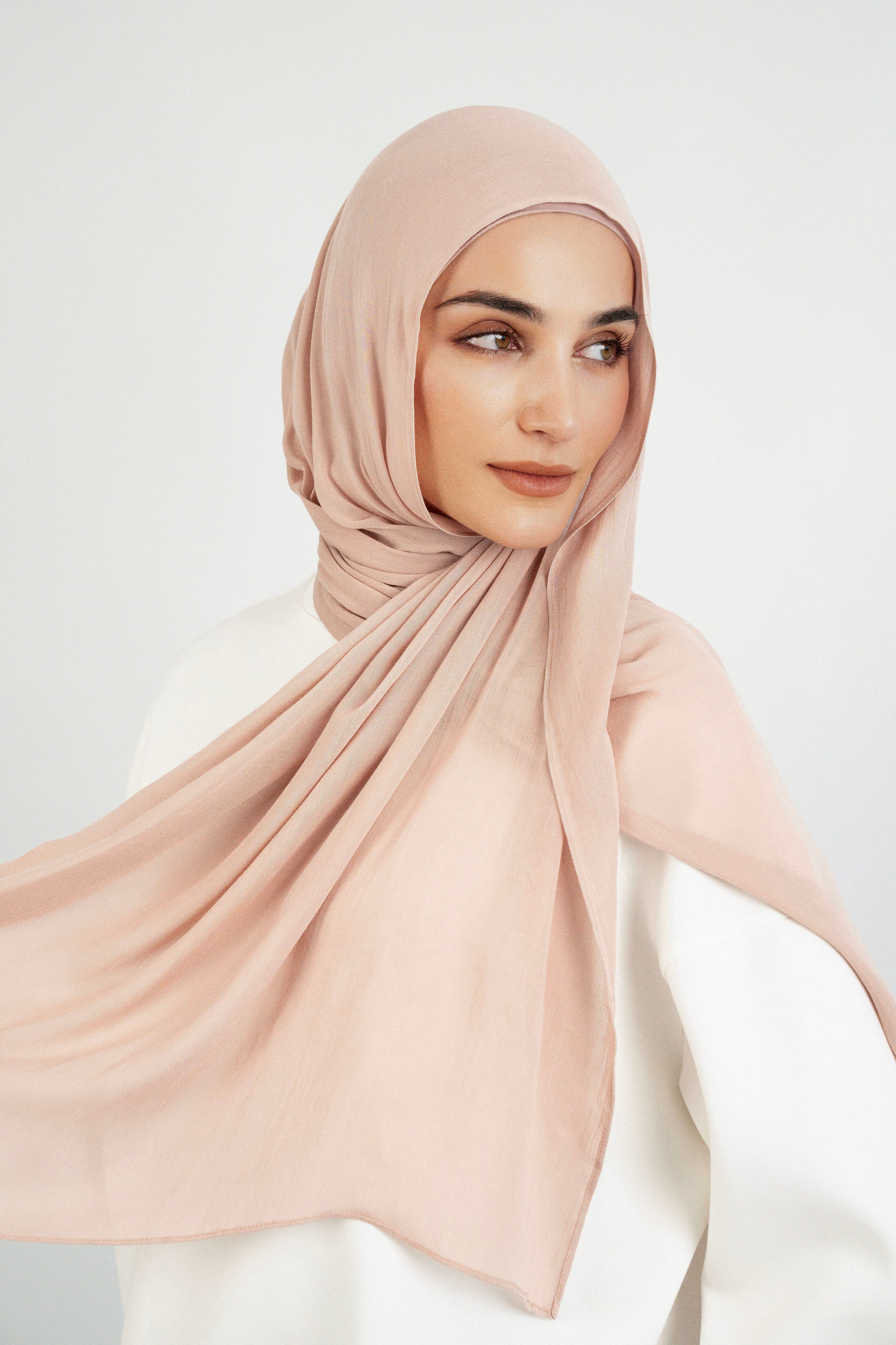 Colour: Seashell. A woman is looking over her left shoulder wearing a Matching Butter Modal Hijab Set