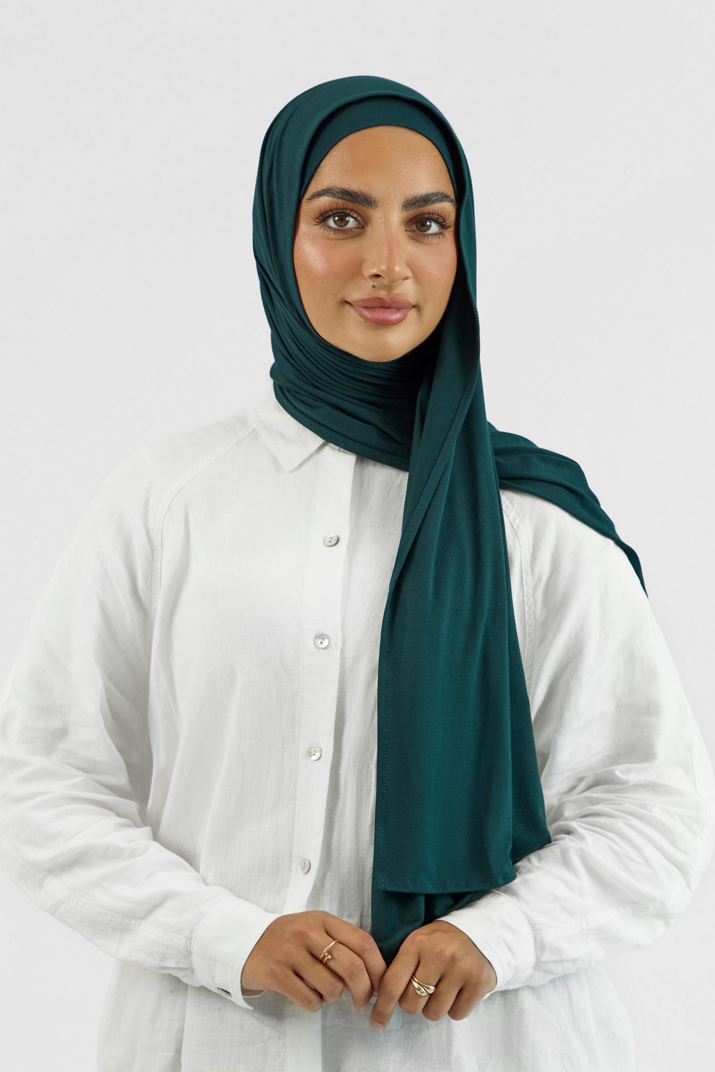 A woman wearing a matching jersey hijab set. Colour description: dark teal.