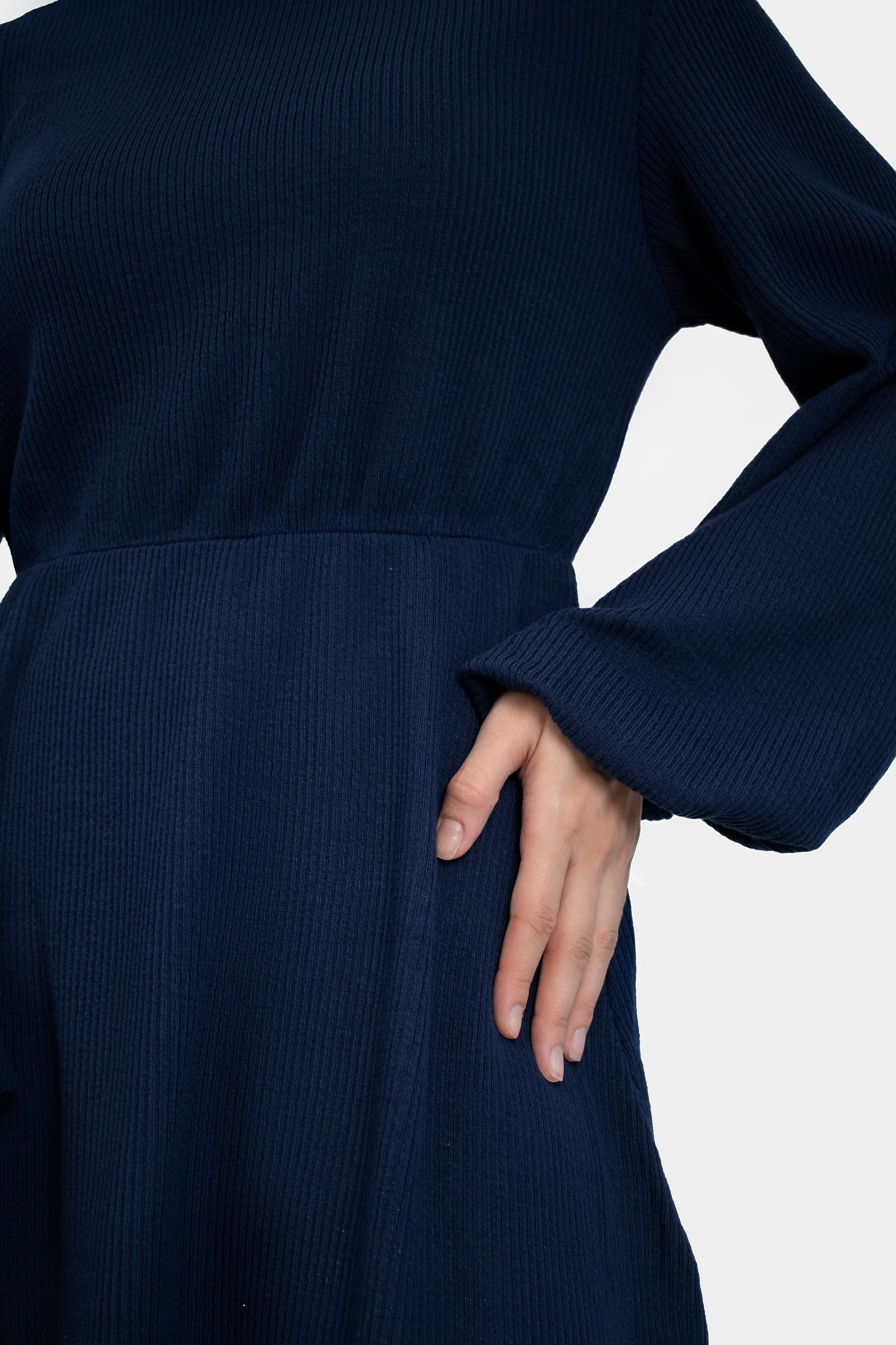 A close up of the Knit Peplum Top on a model.	Colour: Navy