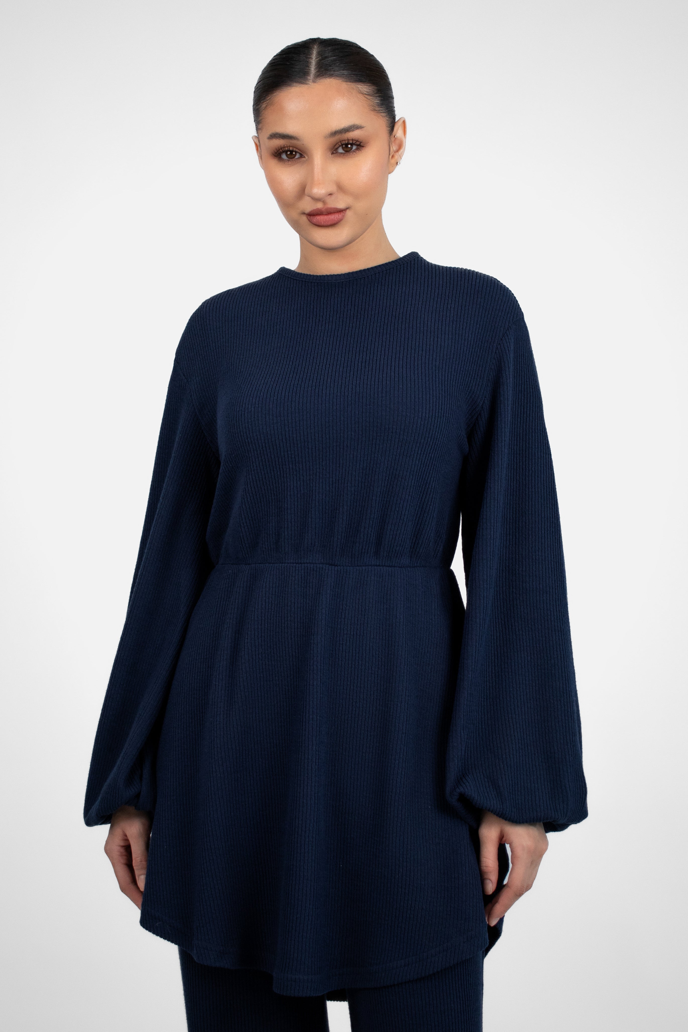 A closer front pose from a girl in a Knit Peplum Top.	Colour: Navy