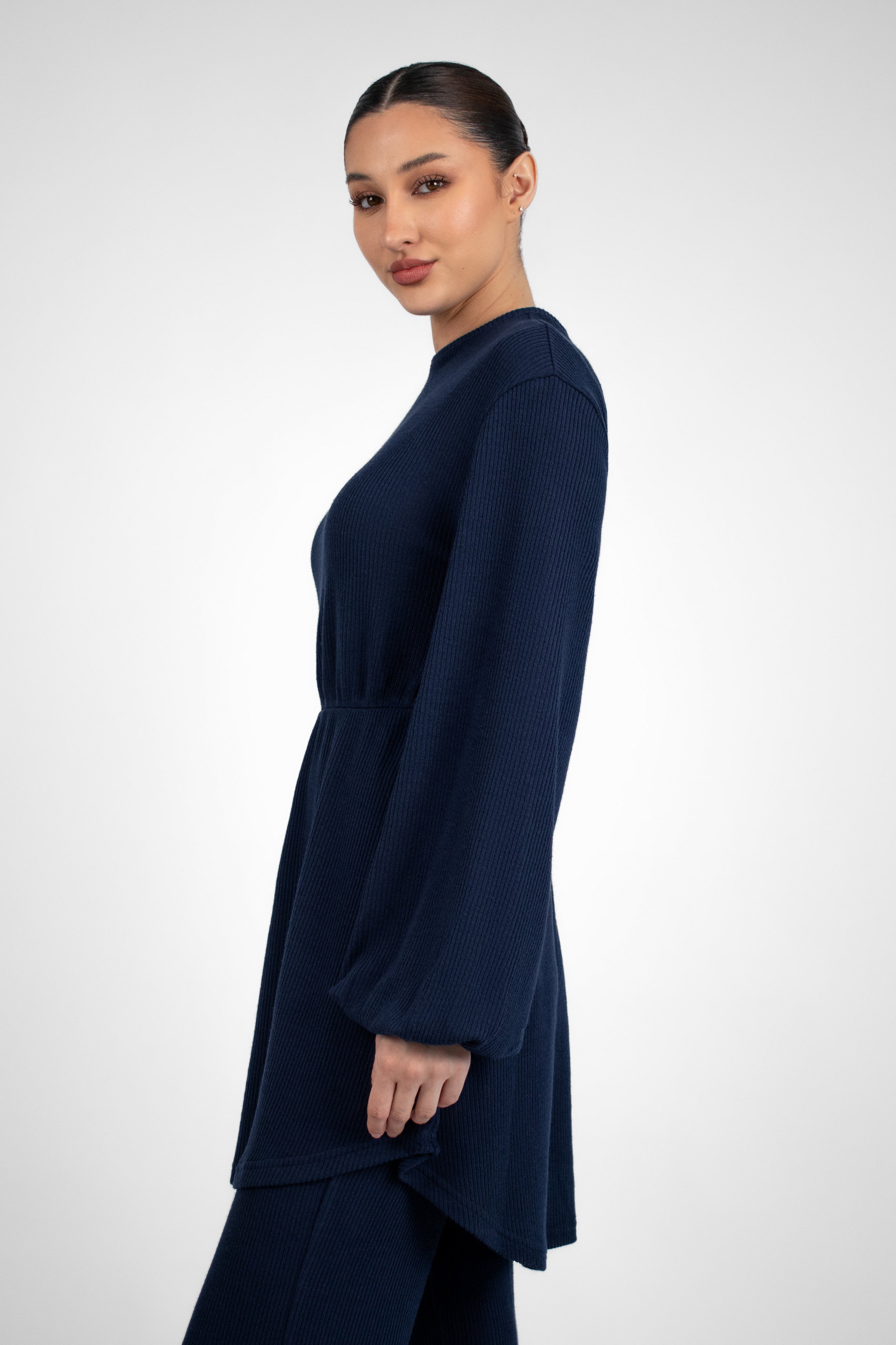 A side pose from a girl in a Knit Peplum Top.	Colour: Navy